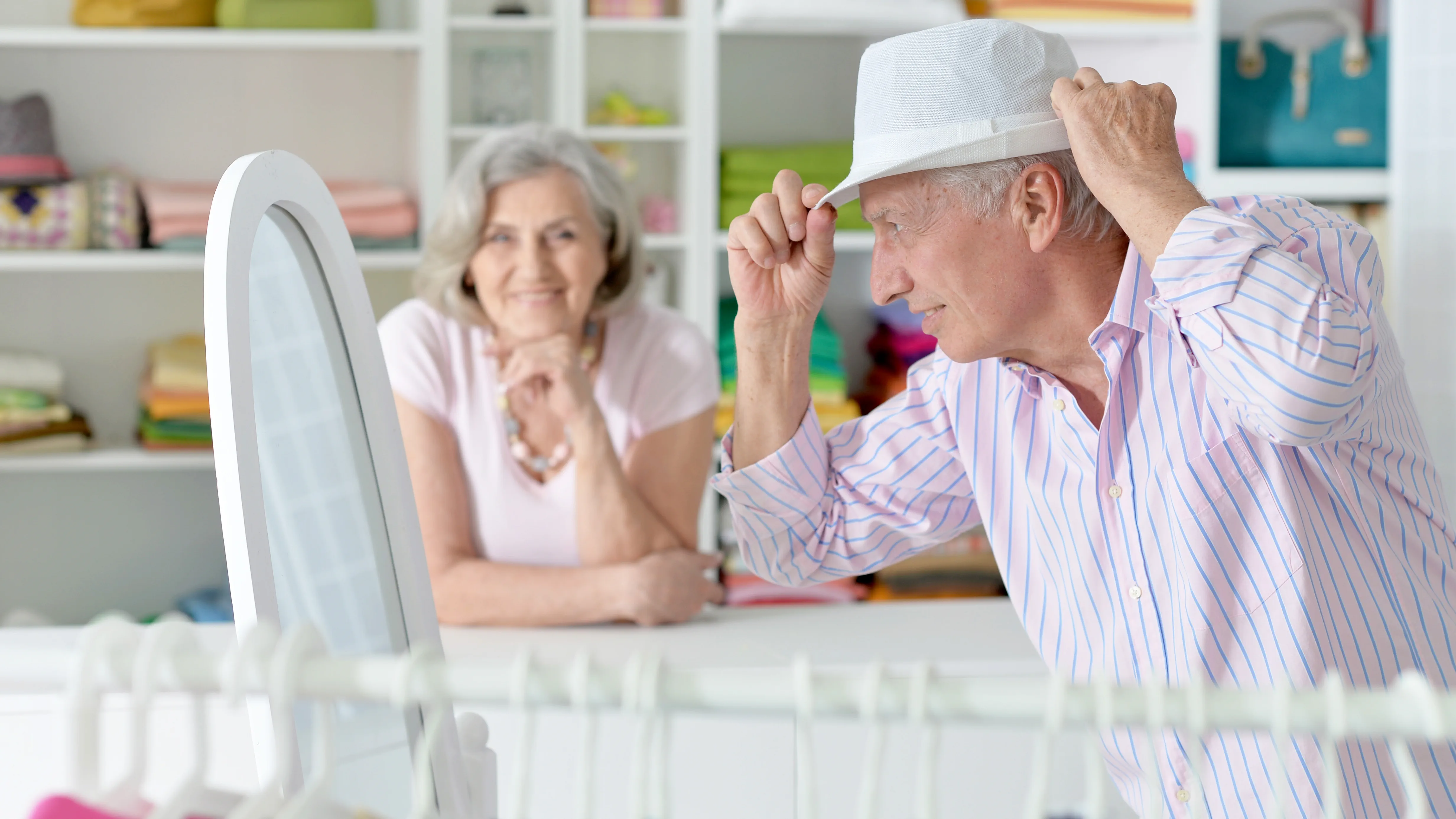 Elderly couple shopping, struggling to hear announcements and conversations due to hearing loss.