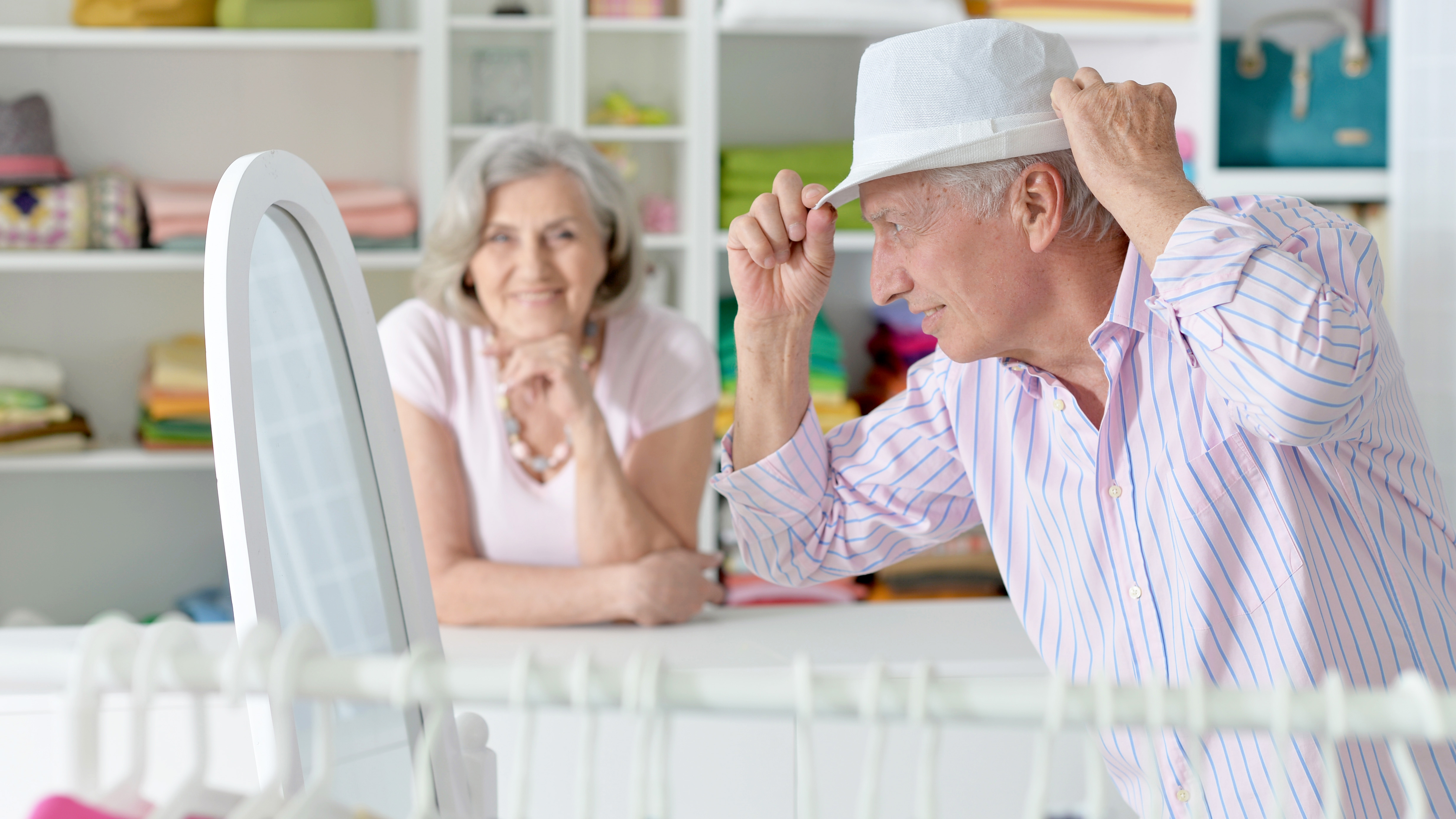 Elderly couple shopping, struggling to hear announcements and conversations due to hearing loss.