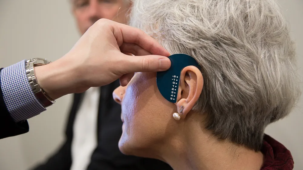 Measuring customers ears for hearing aids. 