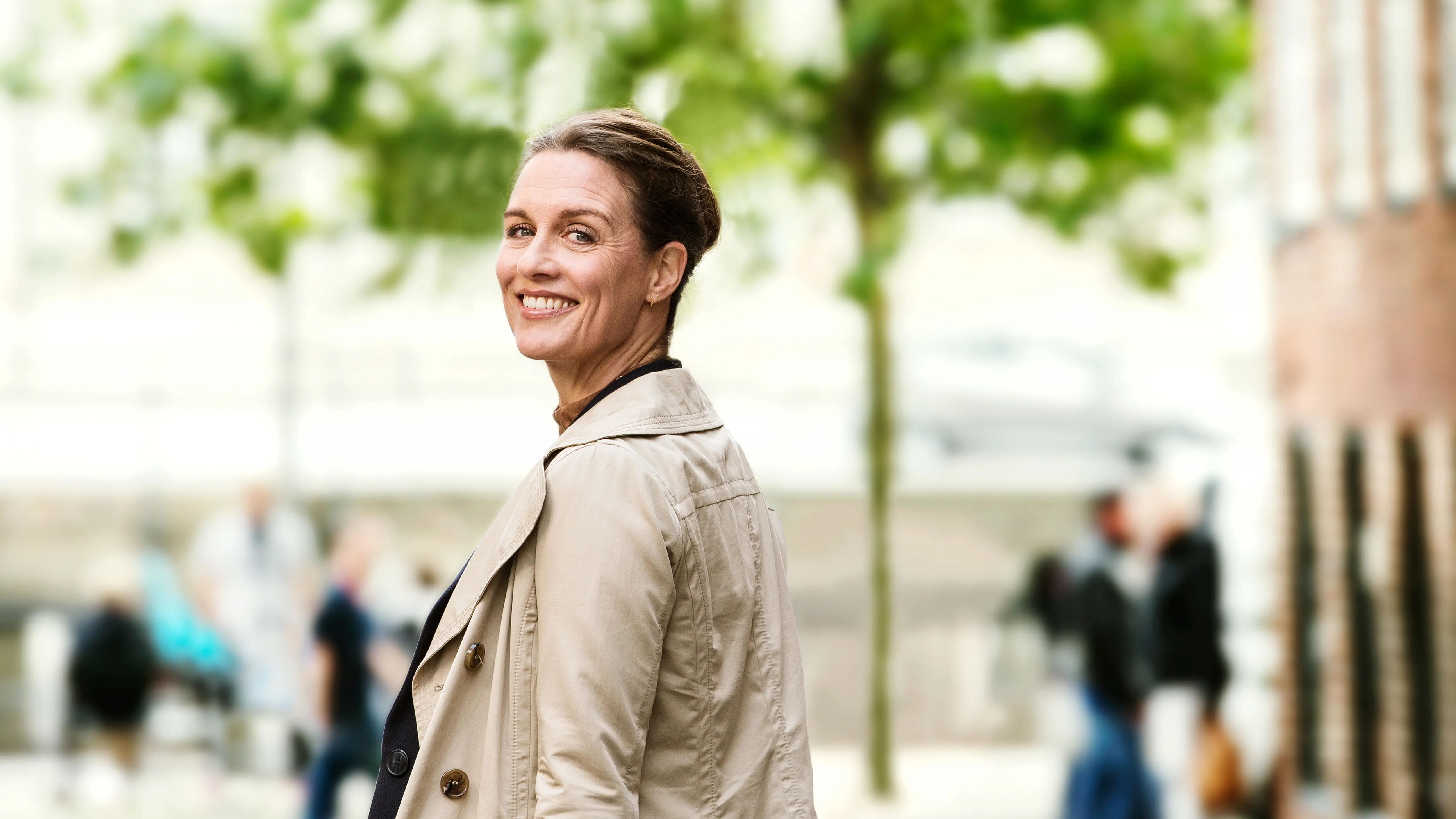 Woman walking in the city, finding it hard to hear amidst the noise due to hearing loss.