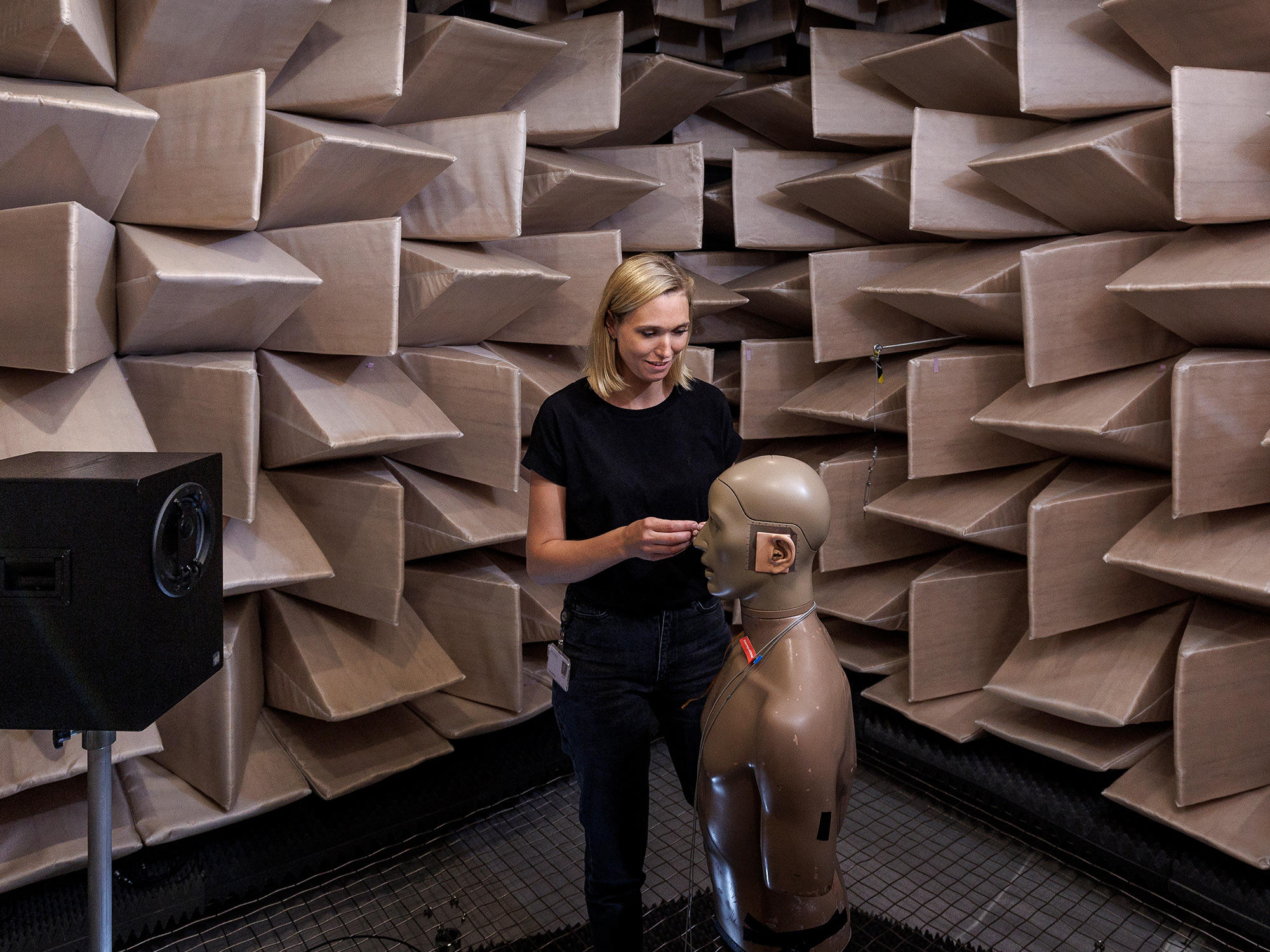 Woman in WSAs sound proff room also all the anechoic chamber where hearing aids are tested.