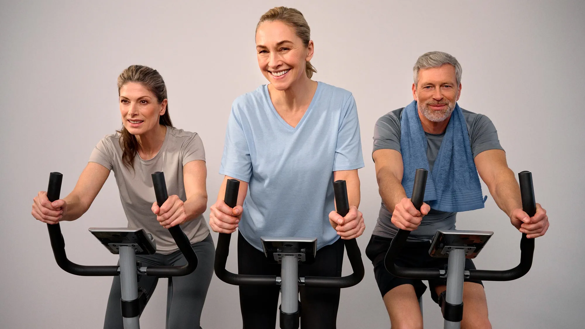 Person smiling during a bike workout, highlighting hearing improvement.