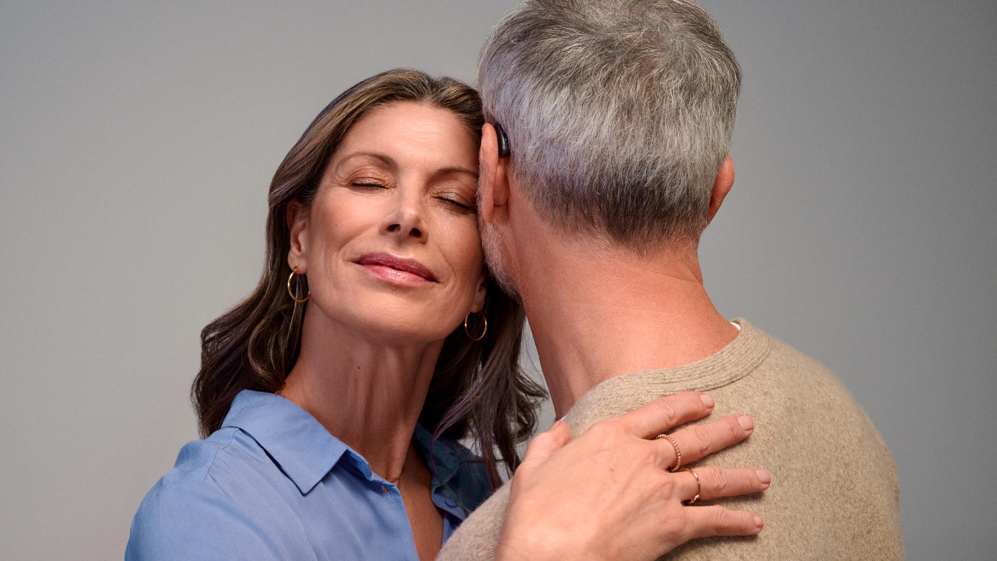 Couple embracing closely, experiencing the benefits of hearing improvement.