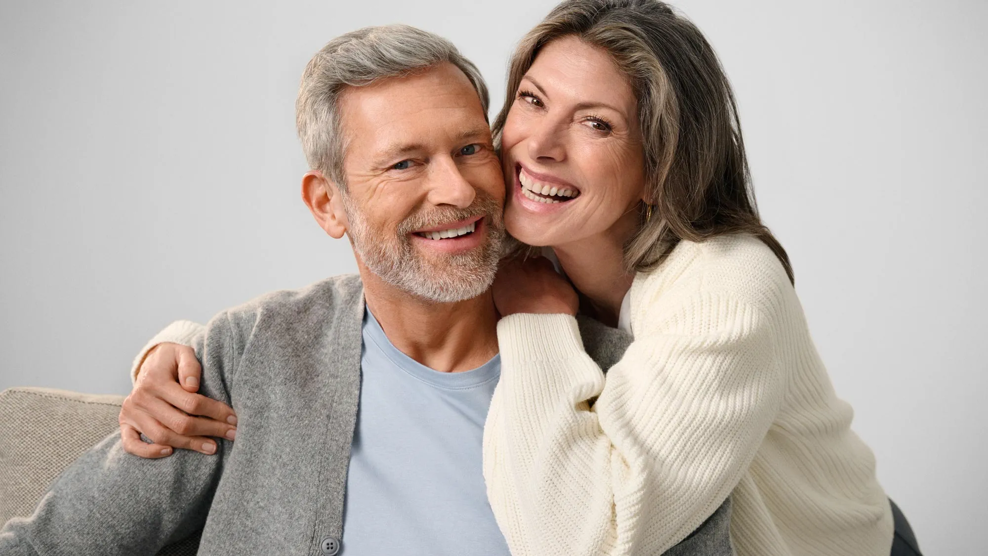 Couple smiling and looking at each other, showing hearing improvement.