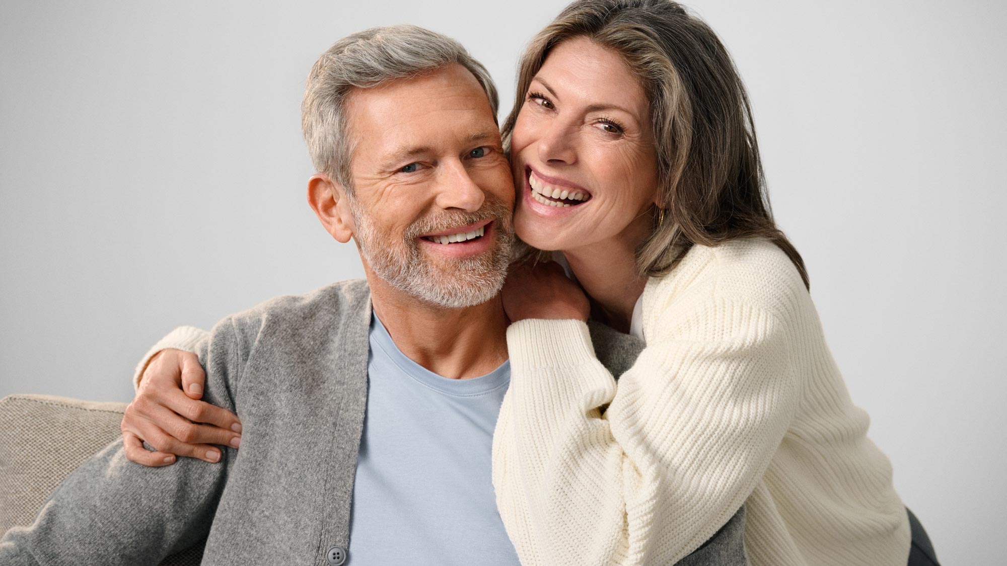 Couple smiling and looking at each other, showing hearing improvement.