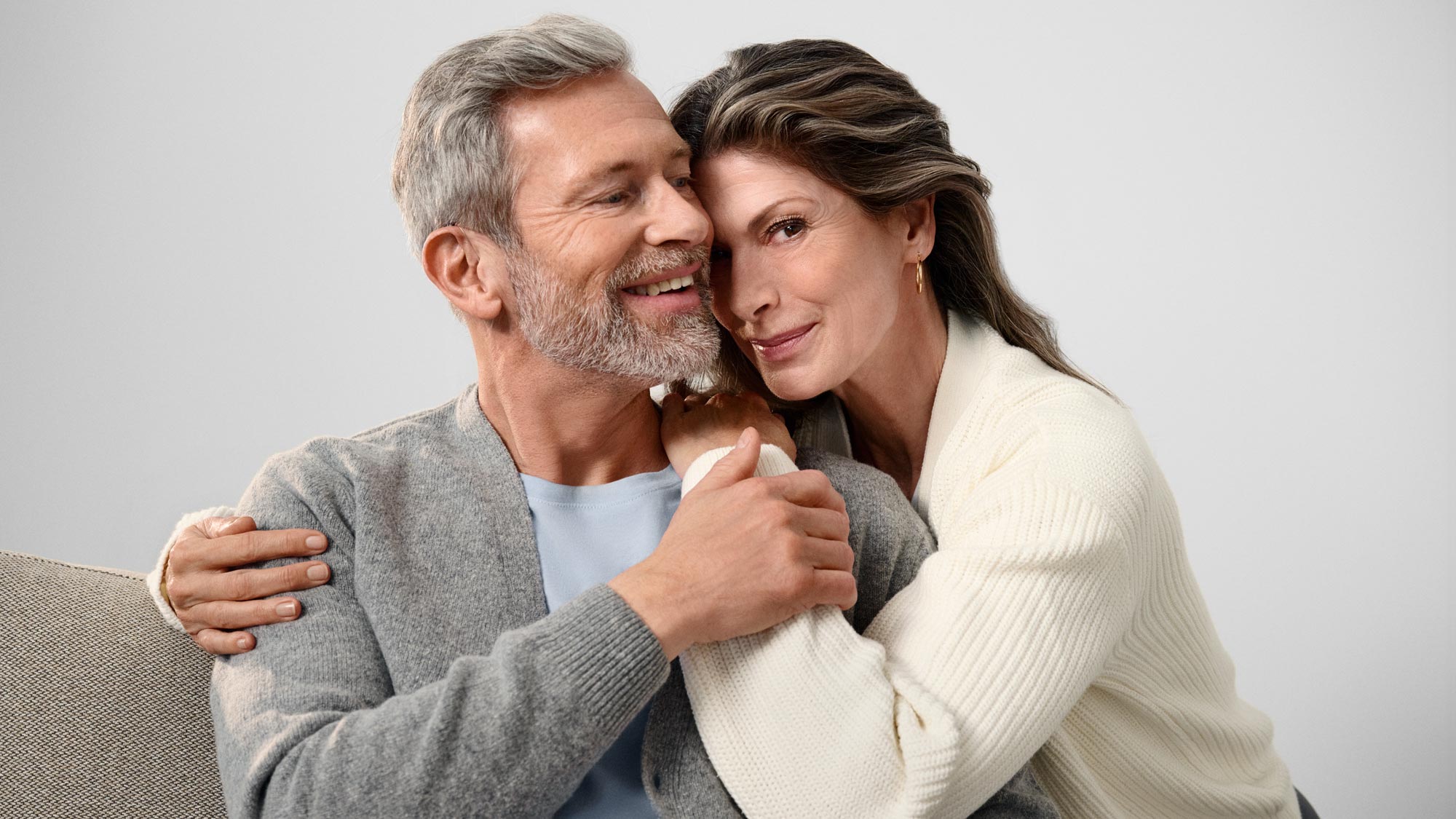 Portrait of a couple embracing, showing hearing improvement.