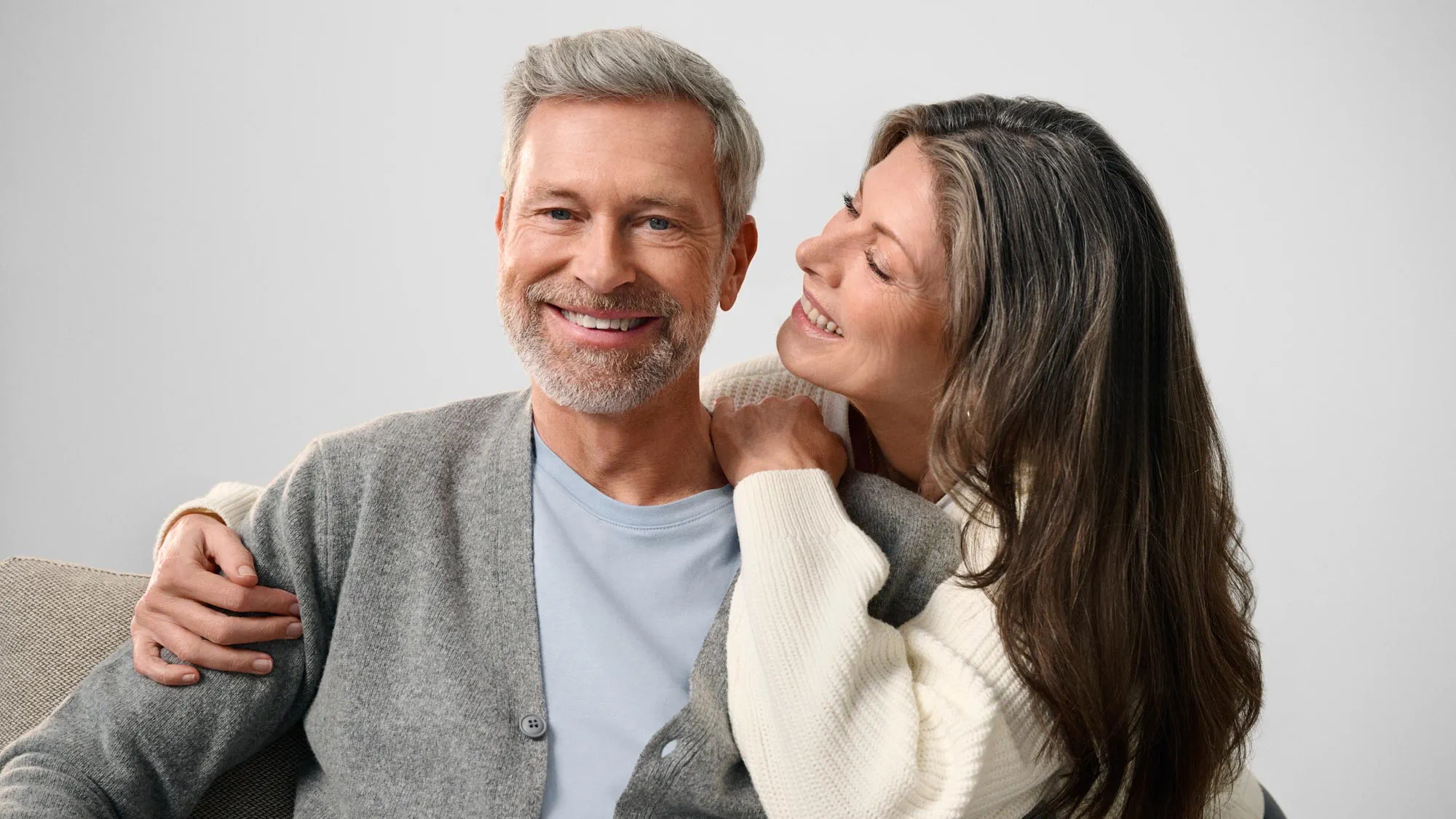Happy man with partner, indicating hearing improvement.