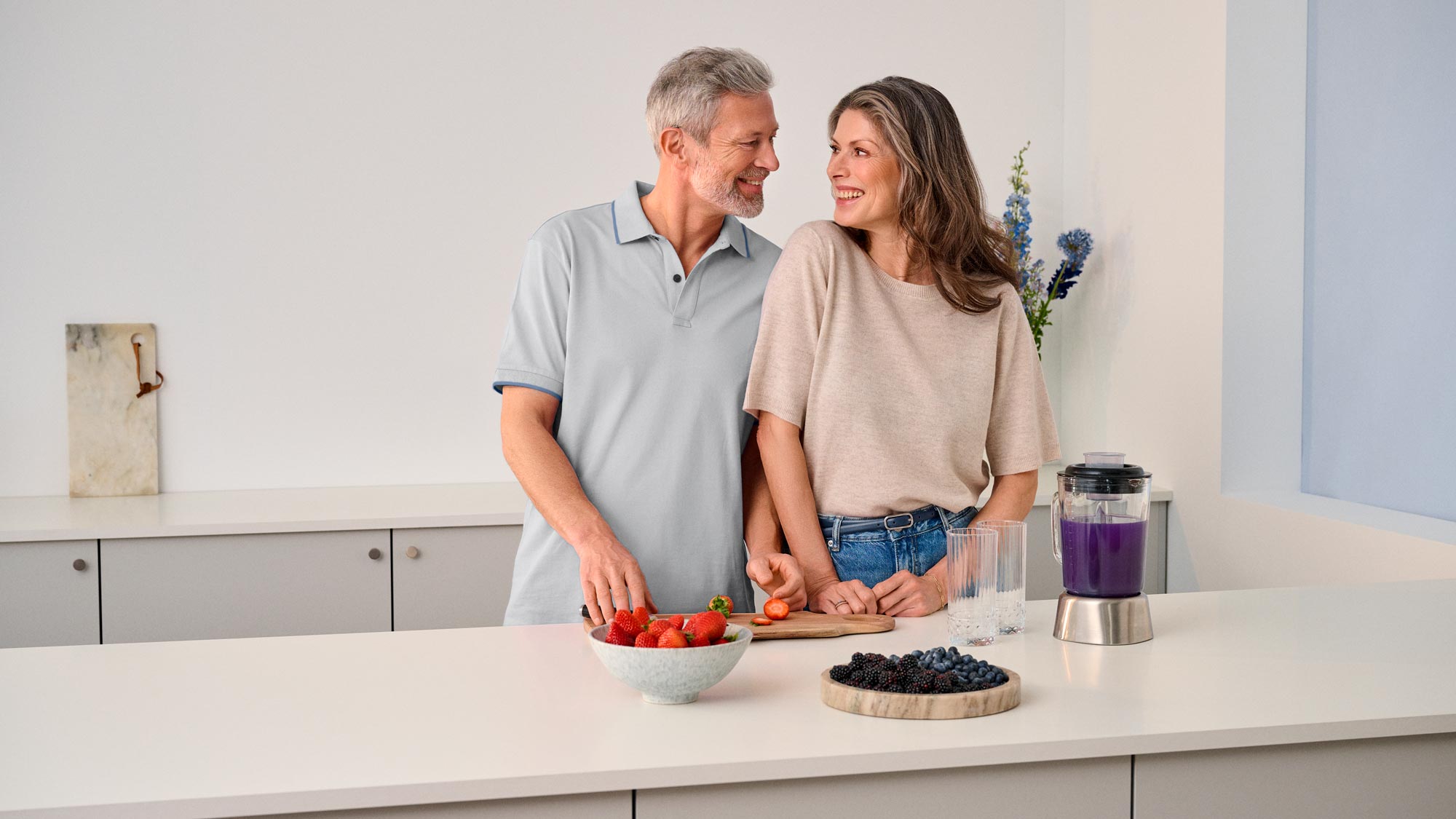 Couple gazing at each other in the kitchen, sharing a moment of hearing improvement.