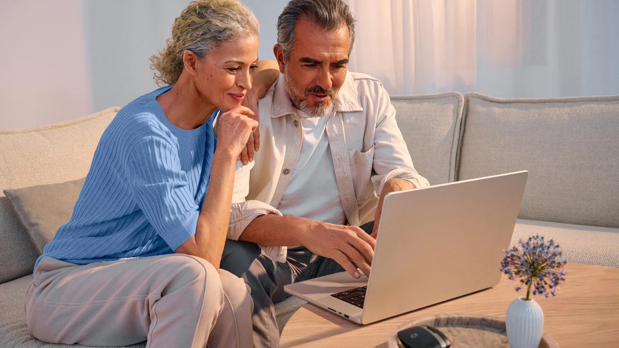 Couple researching on technology together, with their hearing aids on.