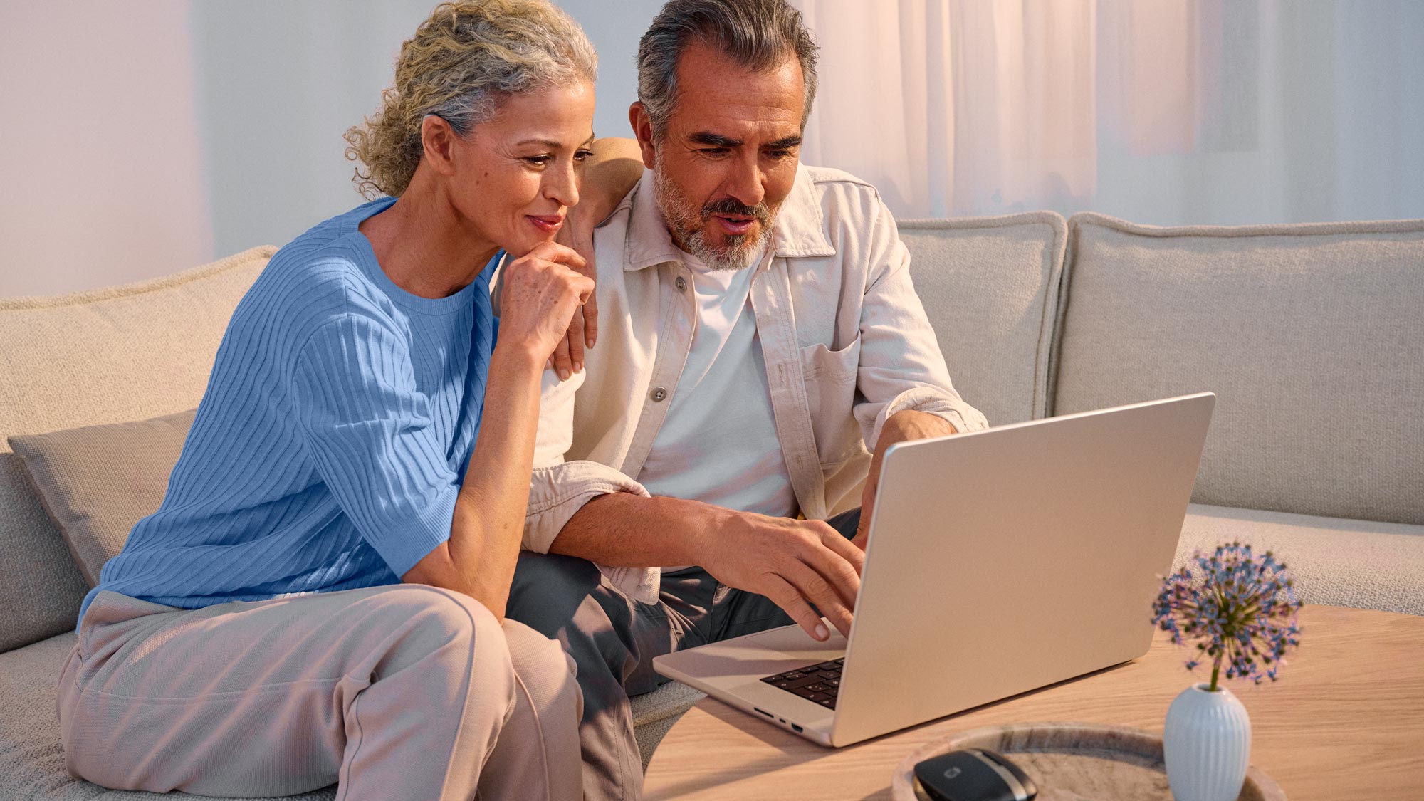 Couple researching on technology together, with their hearing aids on.