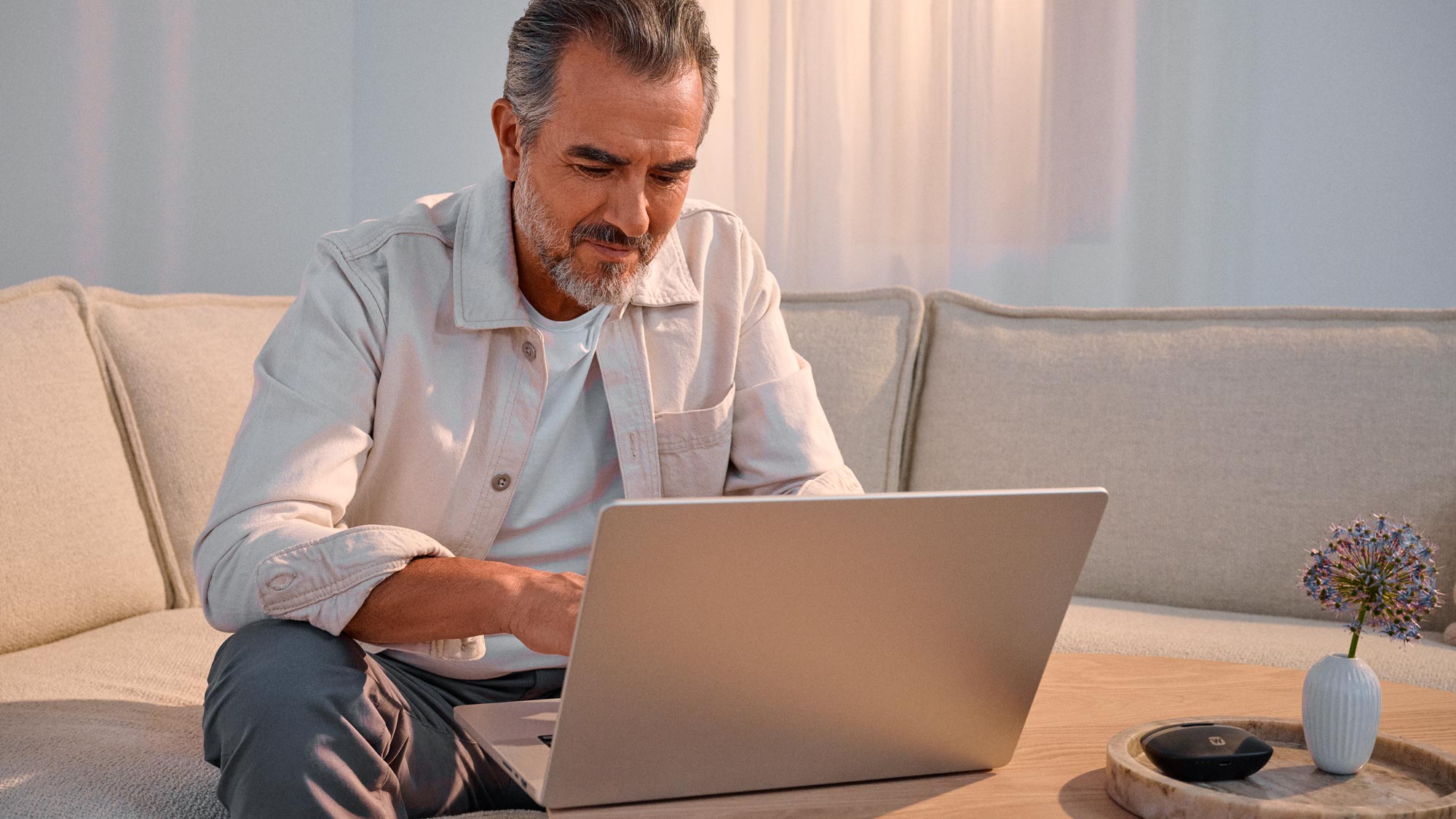 Man researching technology, benefiting from hearing improvement.