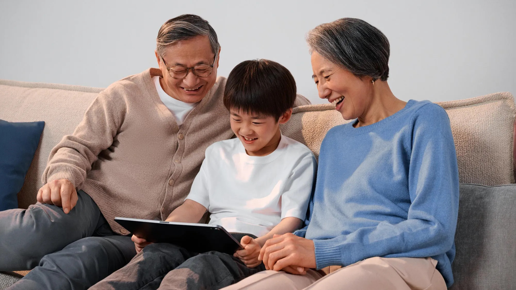 Grandparents enthusiastically using technology, enjoying their hearing improvement.