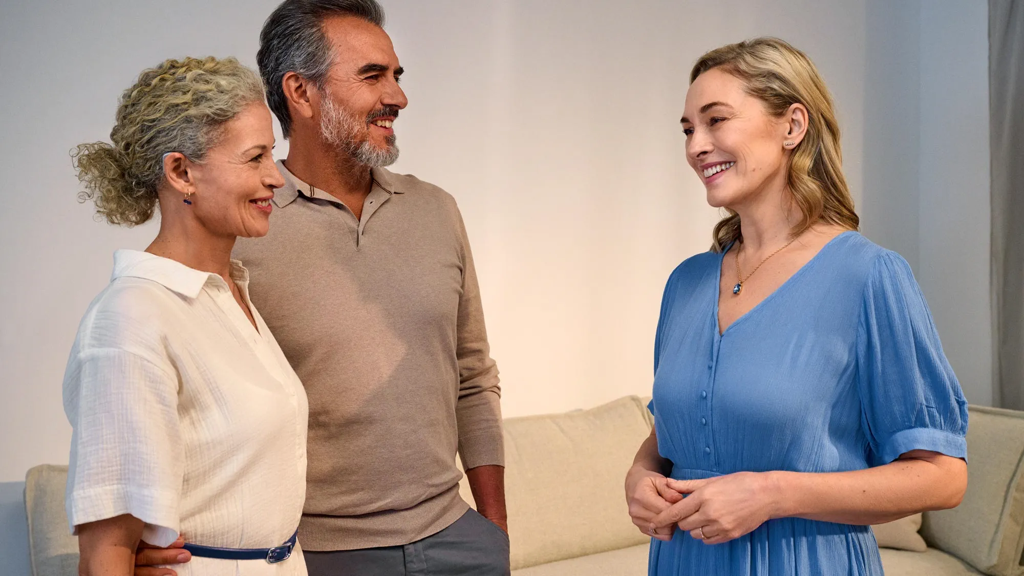 Couple talking with a friend, enjoying conversation thanks to hearing improvement.