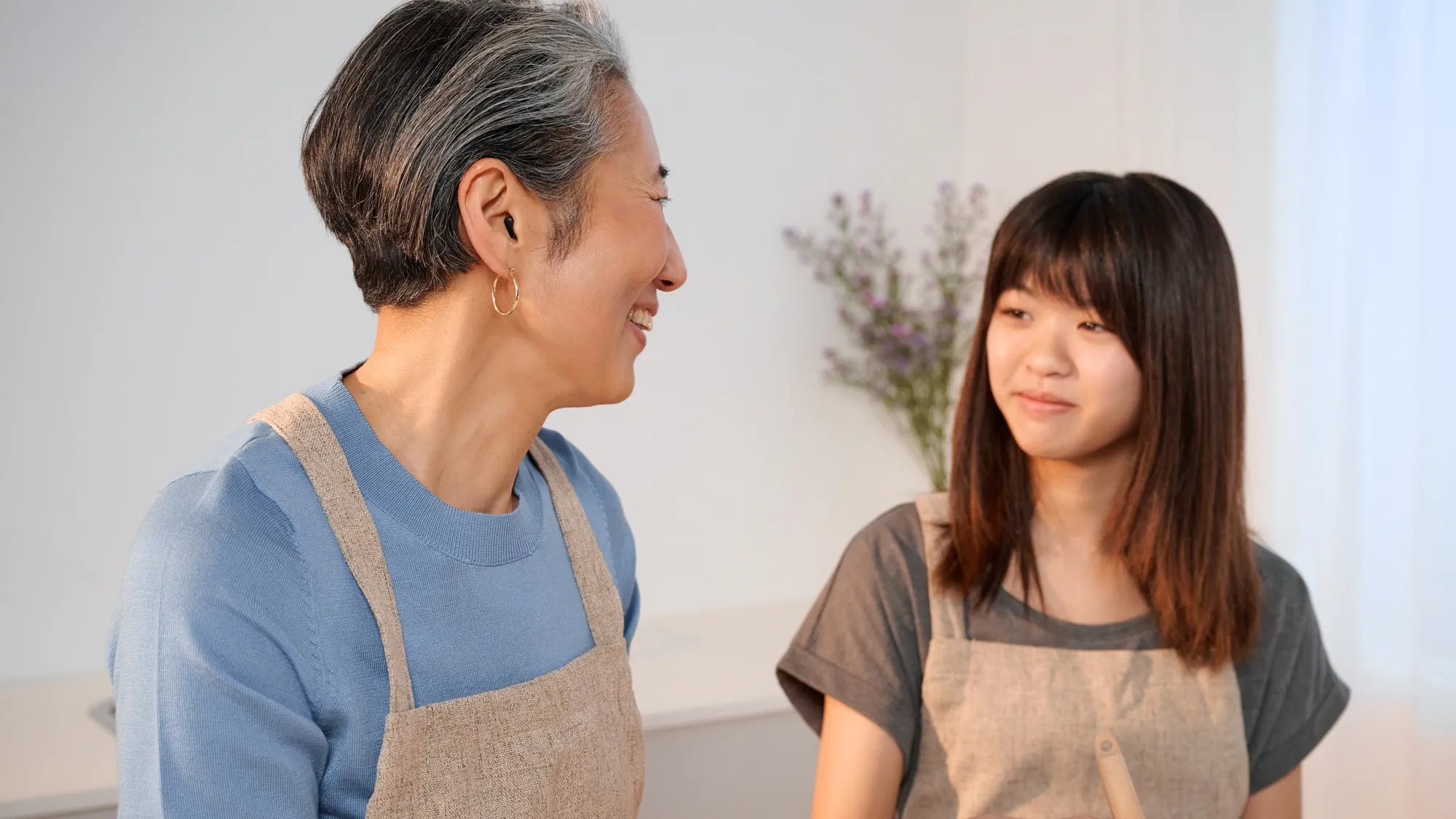 Close-up of a grandmother cooking while wearing hearing aids.