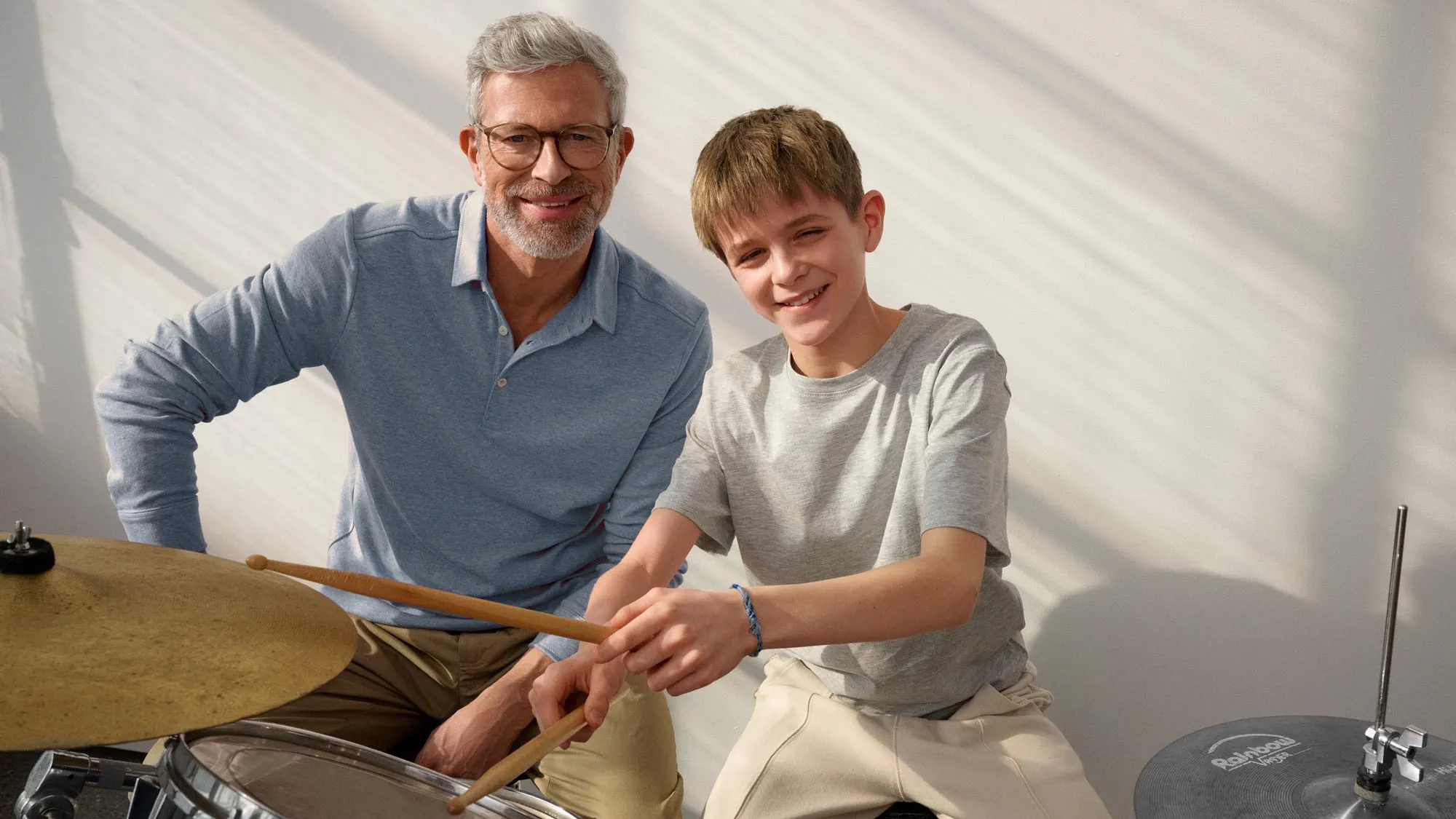 Grandparent and kid smiling, showcasing hearing aids.