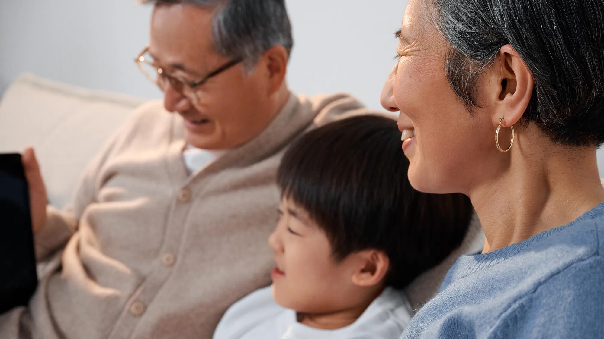 Grandparents enthusiastically using technology, enjoying their hearing improvement.