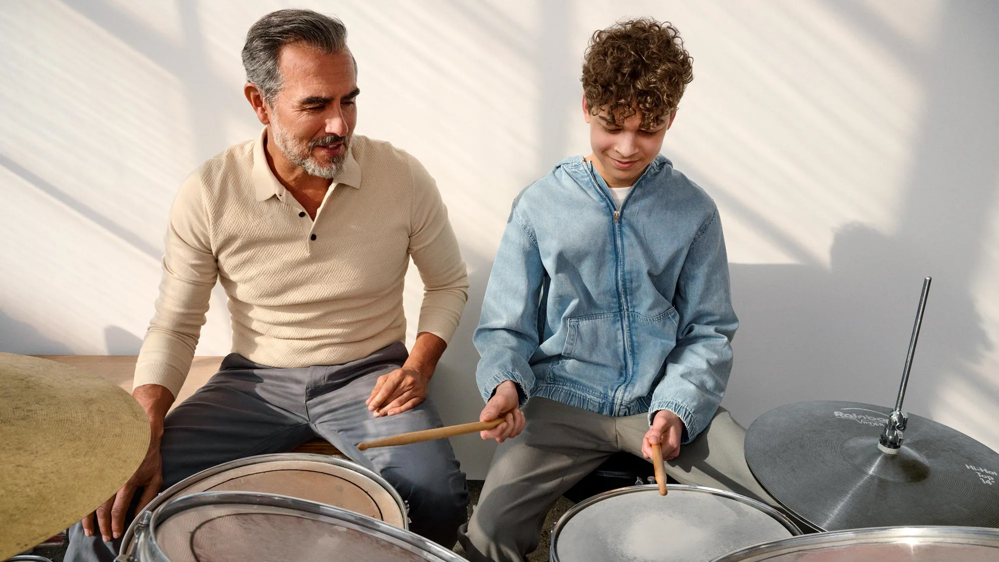 Kid playing the drums, showing signs of hearing improvement.