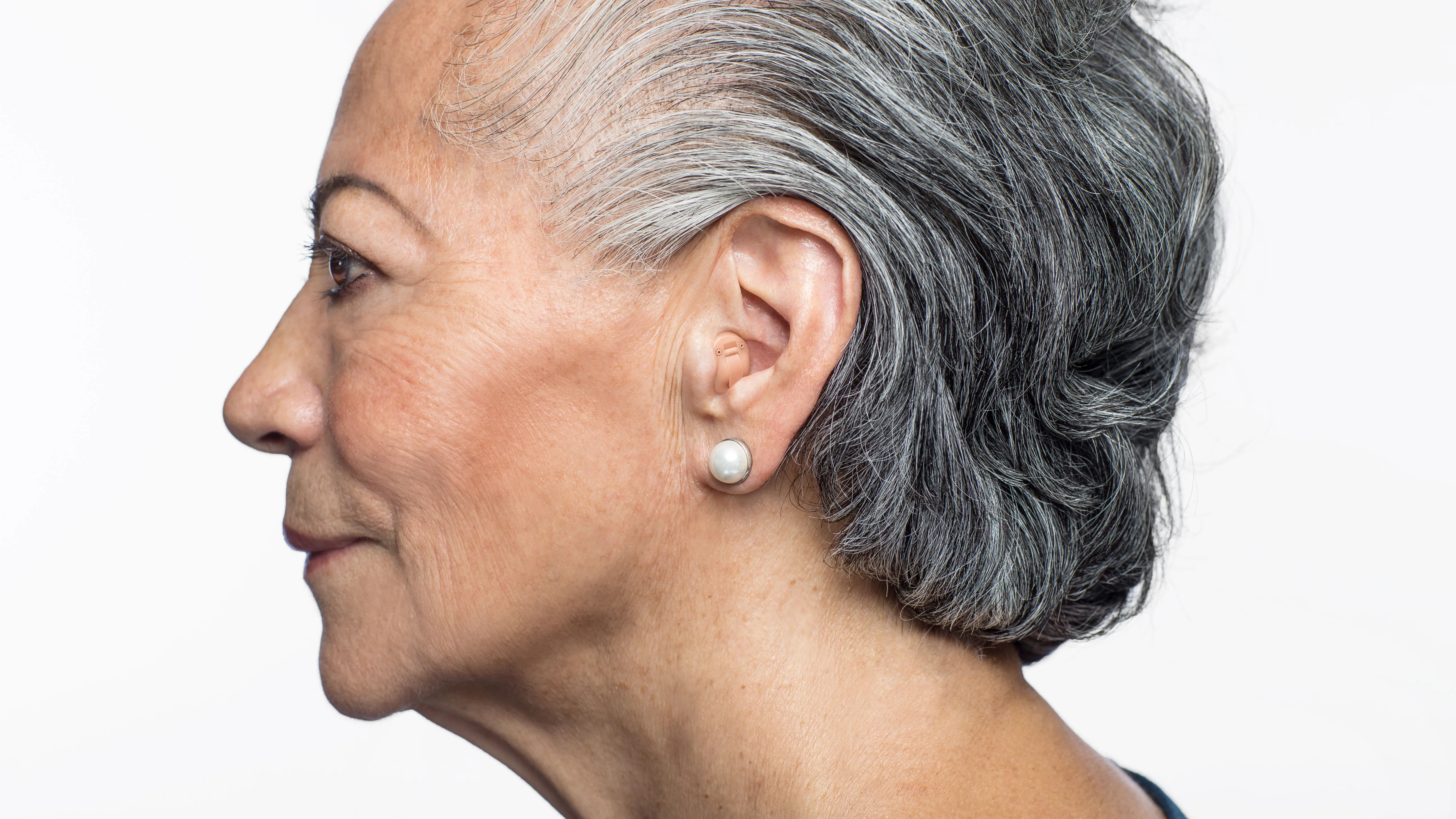 Woman wearing hearing aids side profile shot