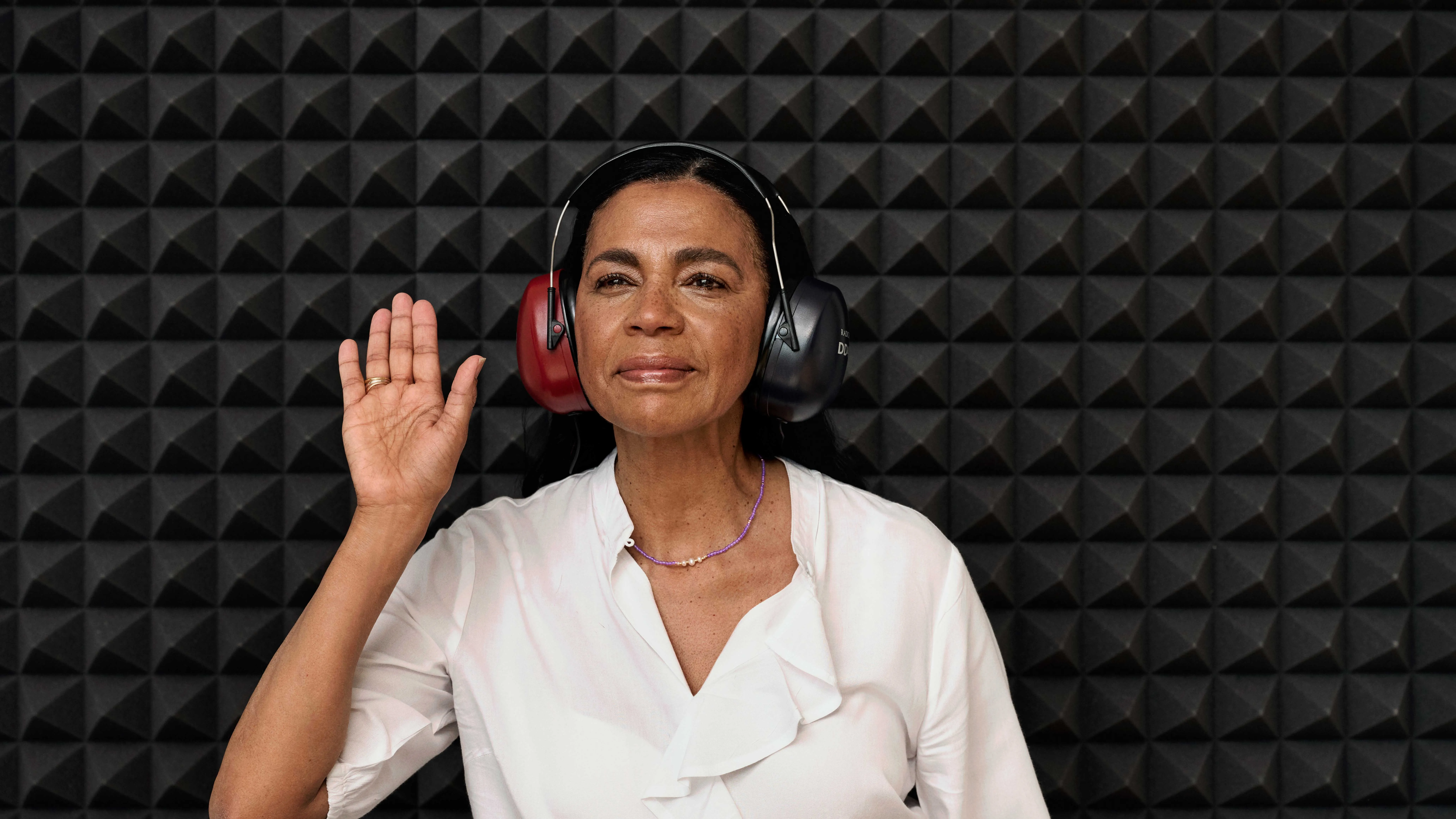 The beginning of a hearing test in a sound booth, with the customer and specialist preparing for the test.
