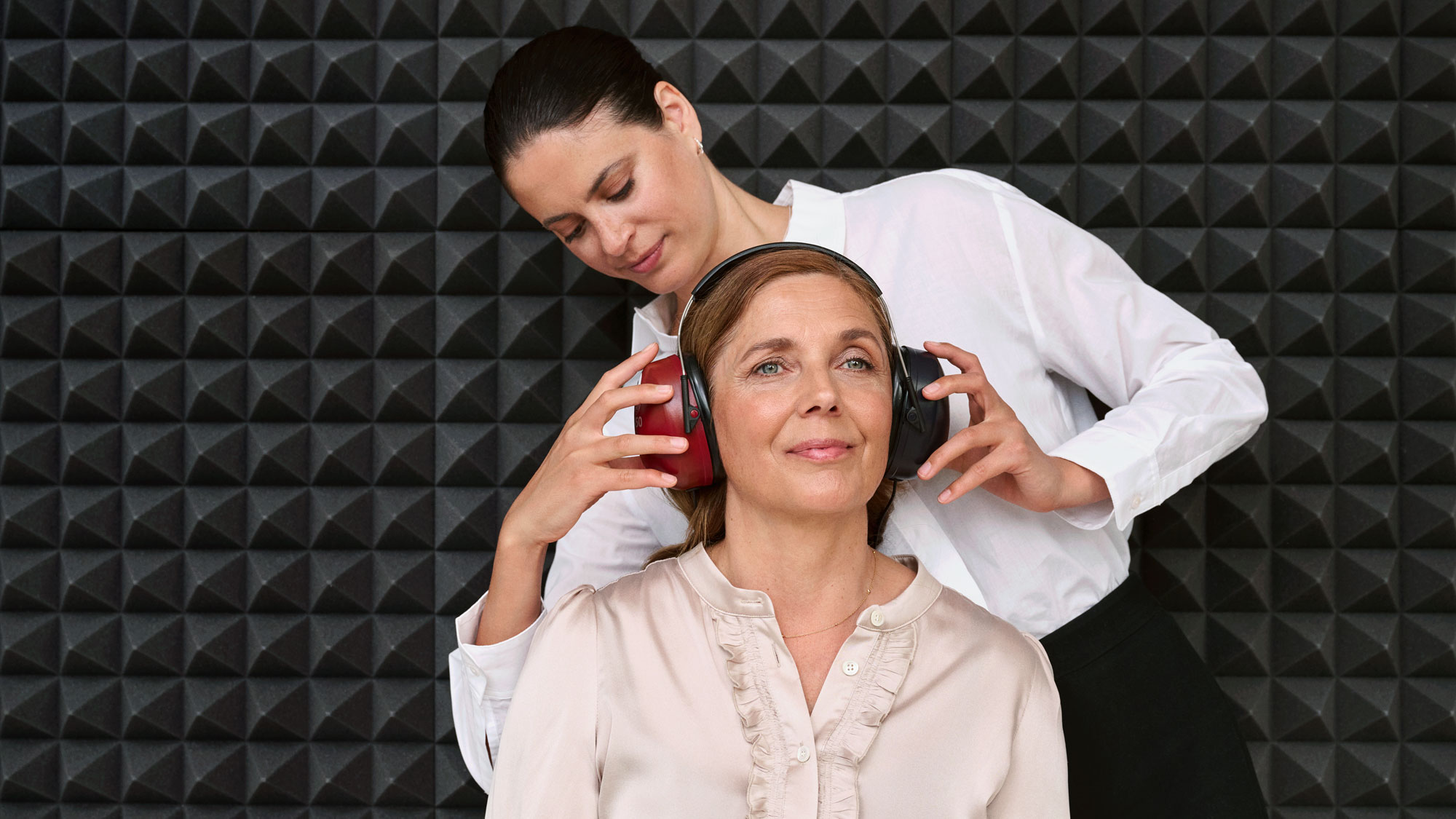 A customer getting a hearing test inside a sound booth during a hearing appointment.
