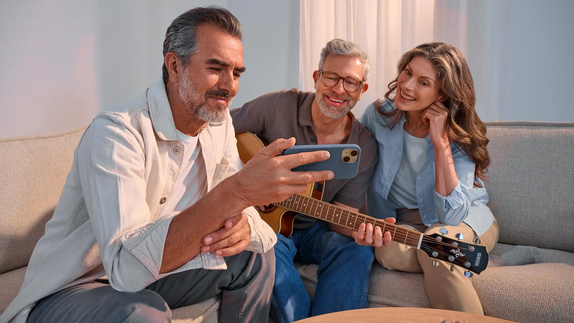 Friends watching something on a phone, celebrating their hearing improvement.