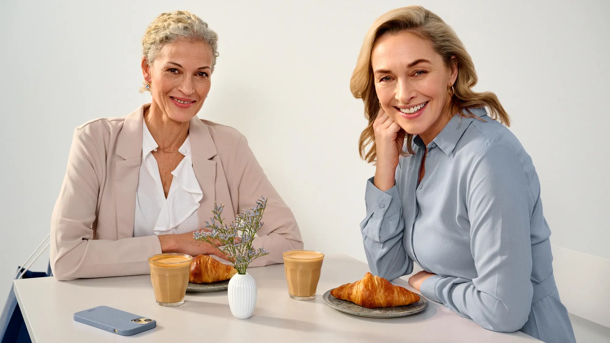 Friends enjoying time at a cafe, wearing hearing aids.