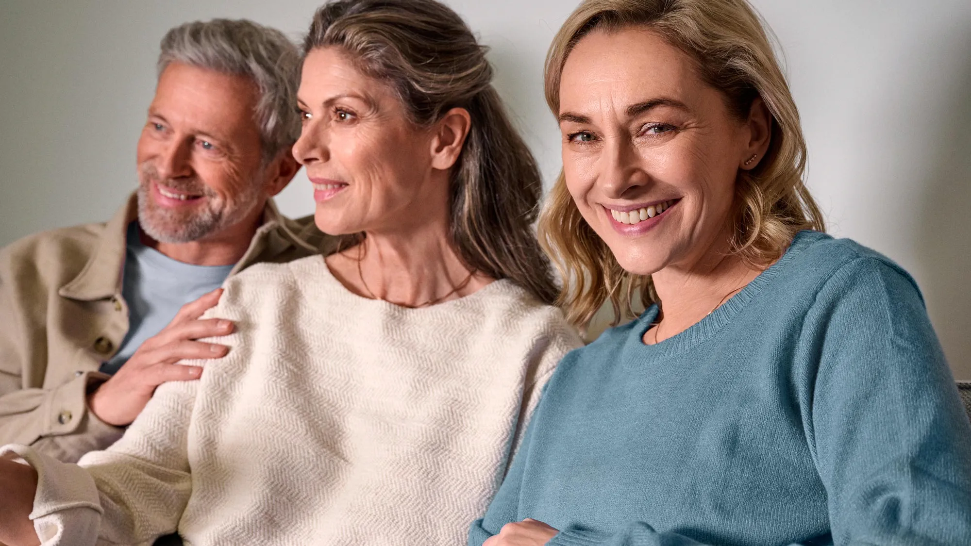 Friends watching TV together, showcasing hearing aids.