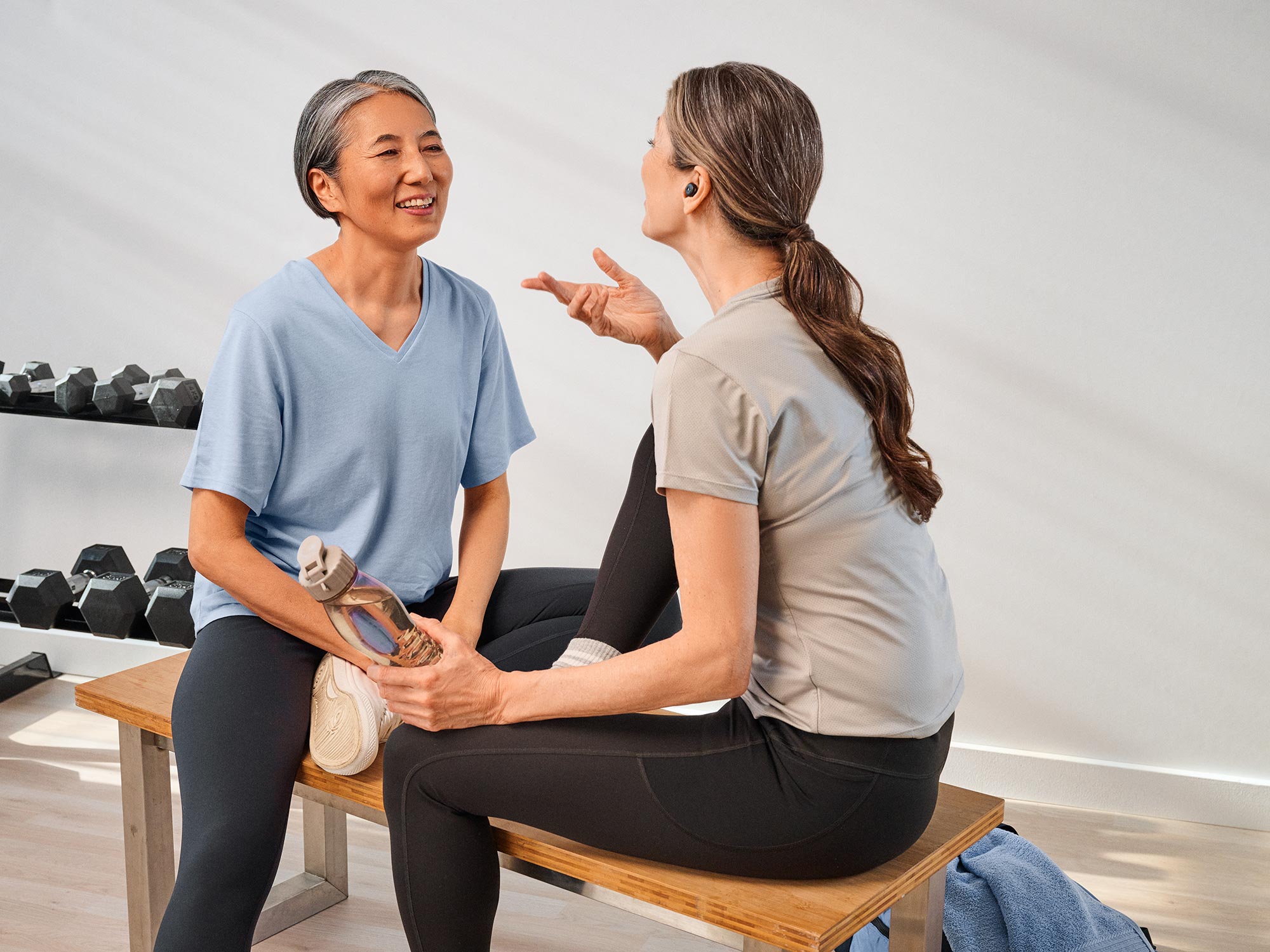 Group of friends sitting together at the gym, all with hearing aids.