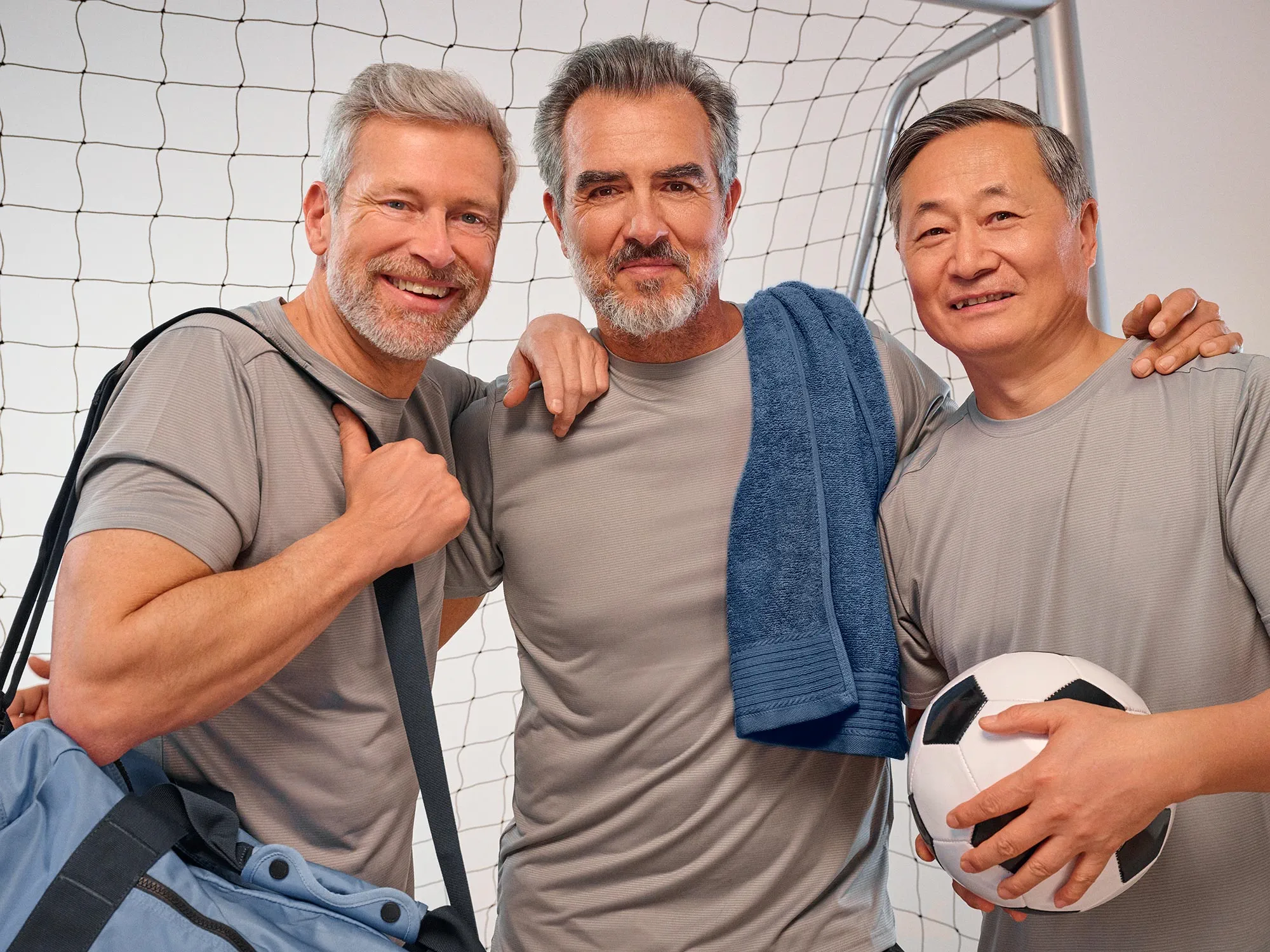 Portrait of friends playing soccer, showcasing hearing aids.
