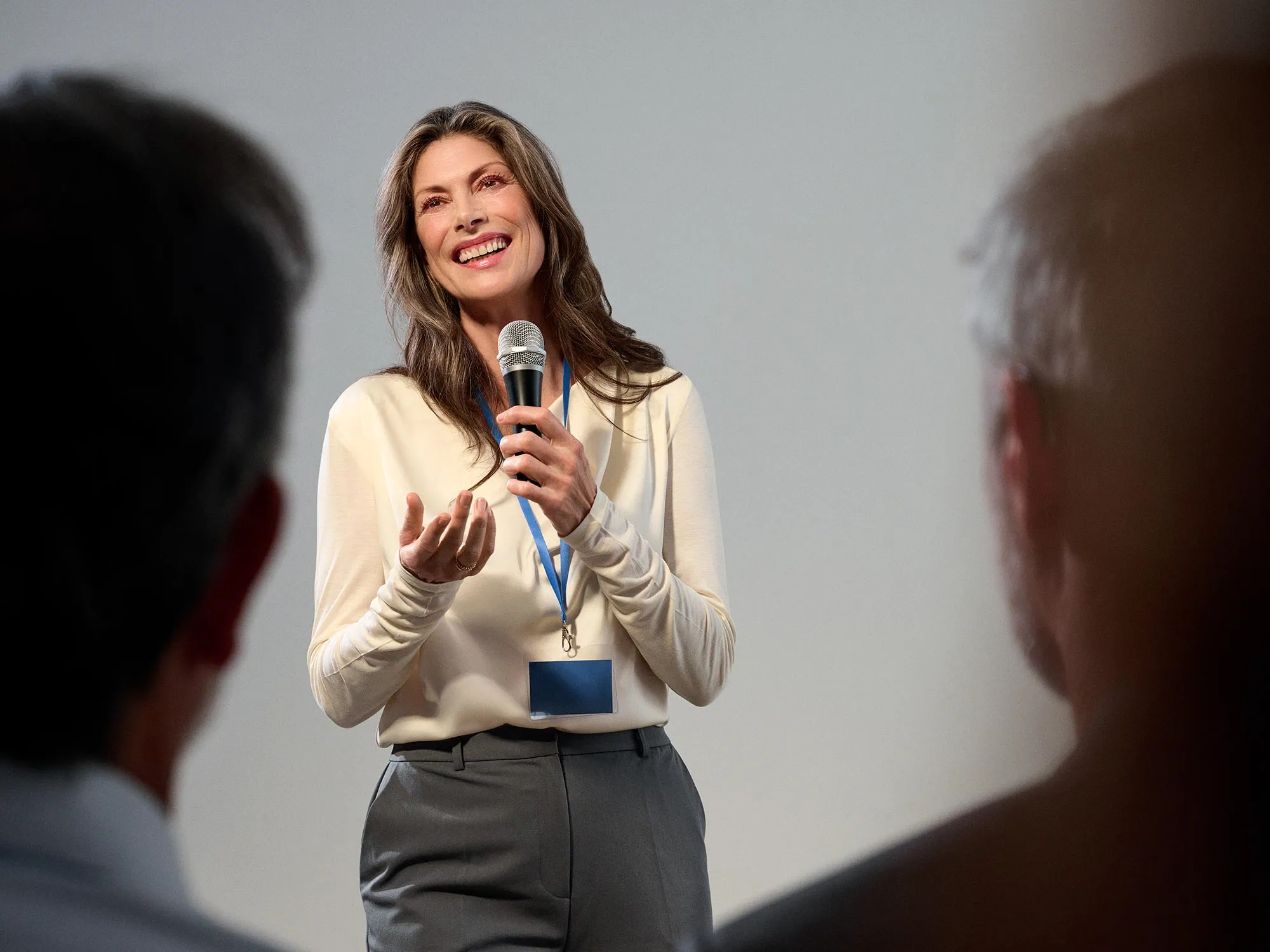 Woman presenting to an audience, confidently wearing hearing aids.