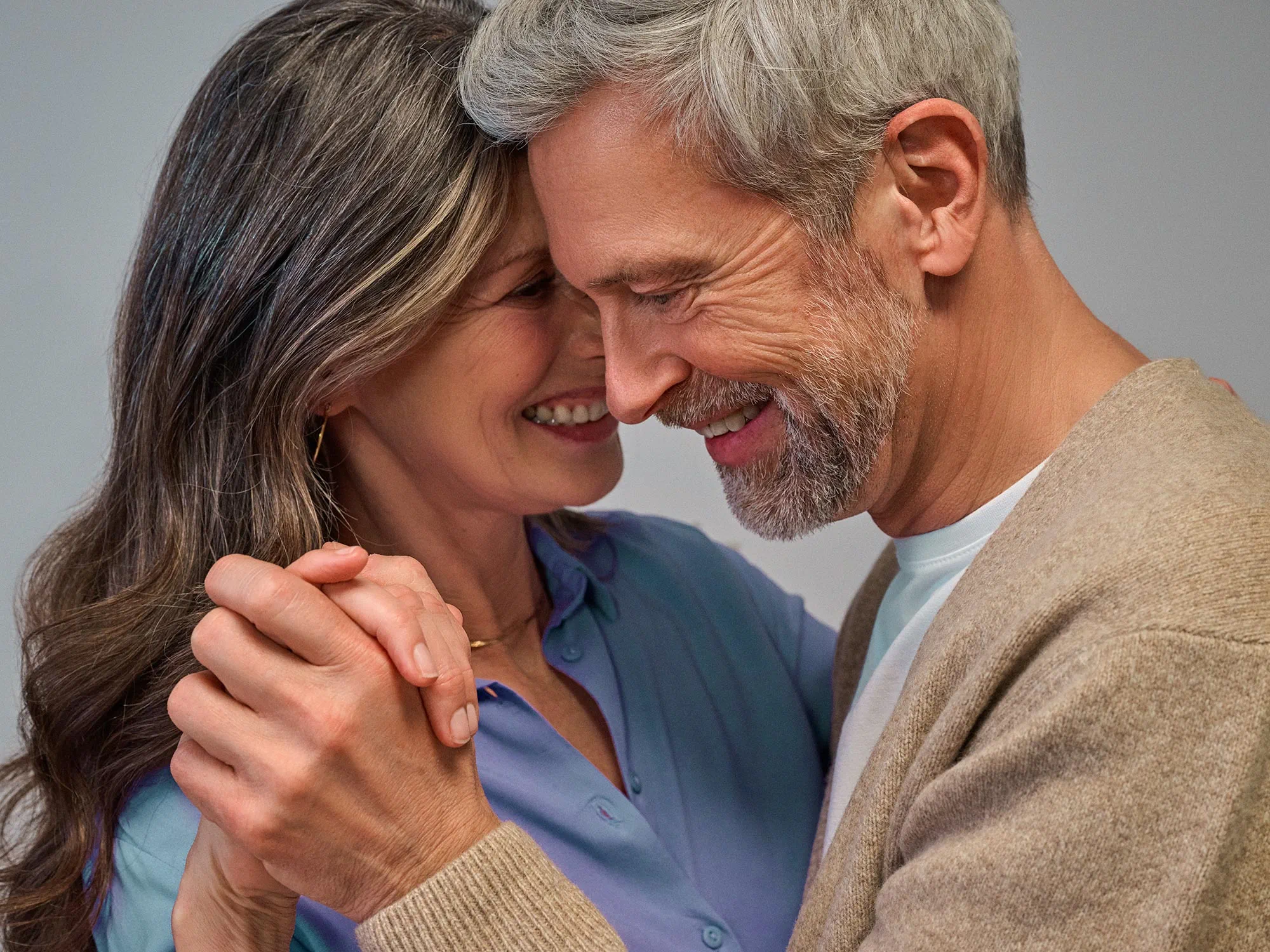 Couple dancing closely, smiling and enjoying hearing improvement.