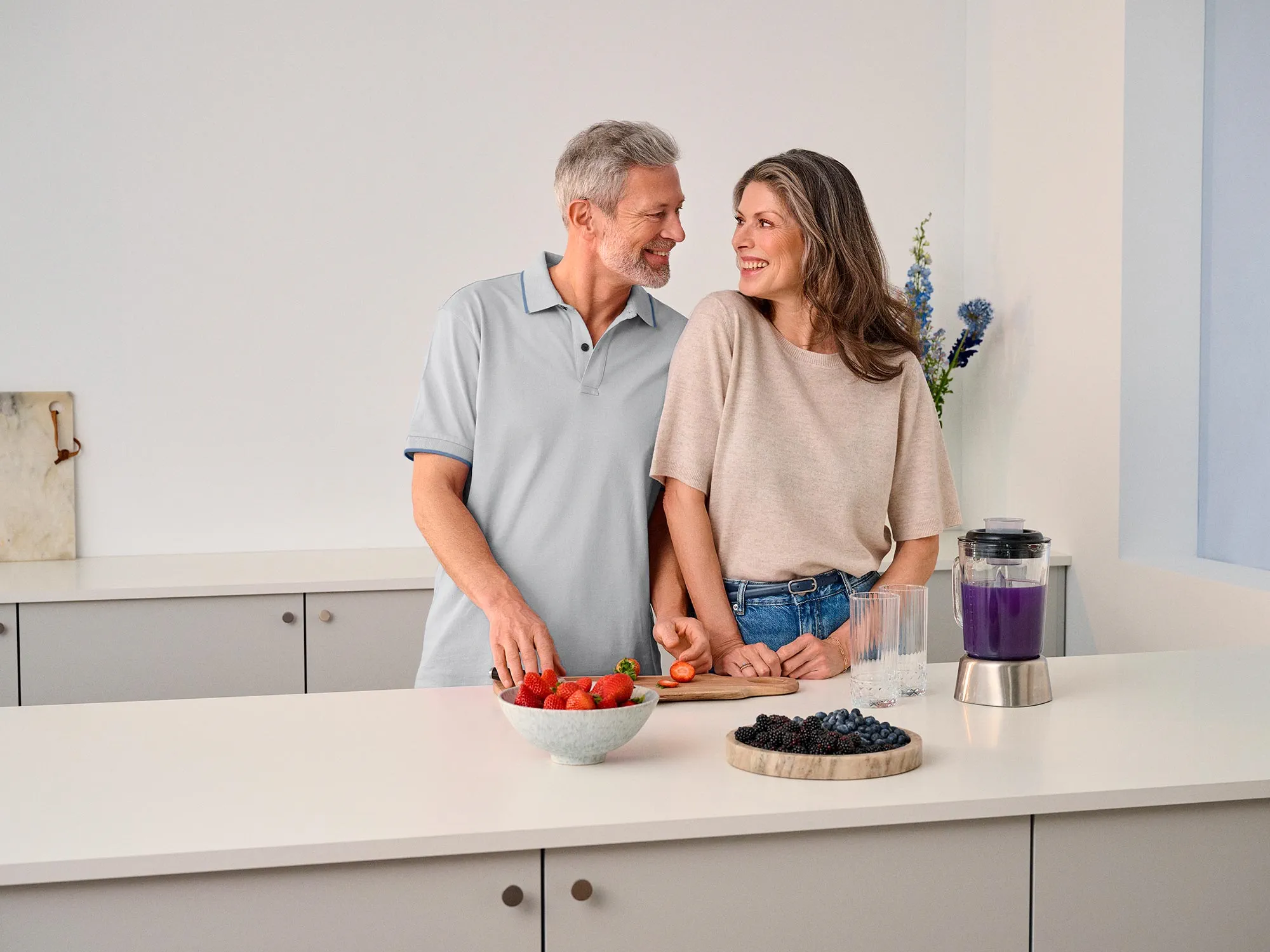 Couple gazing at each other in the kitchen, sharing a moment of hearing improvement.