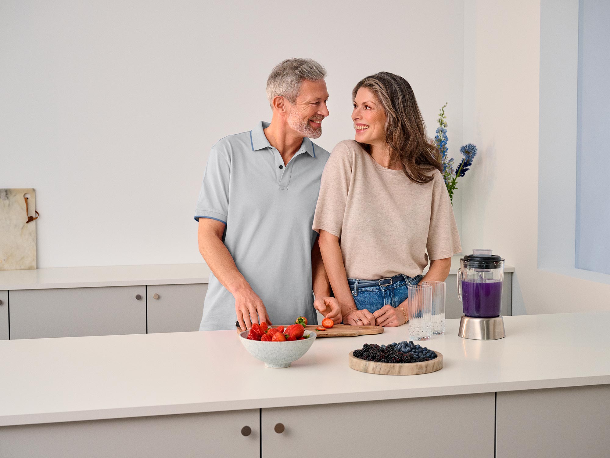 Couple gazing at each other in the kitchen, sharing a moment of hearing improvement.