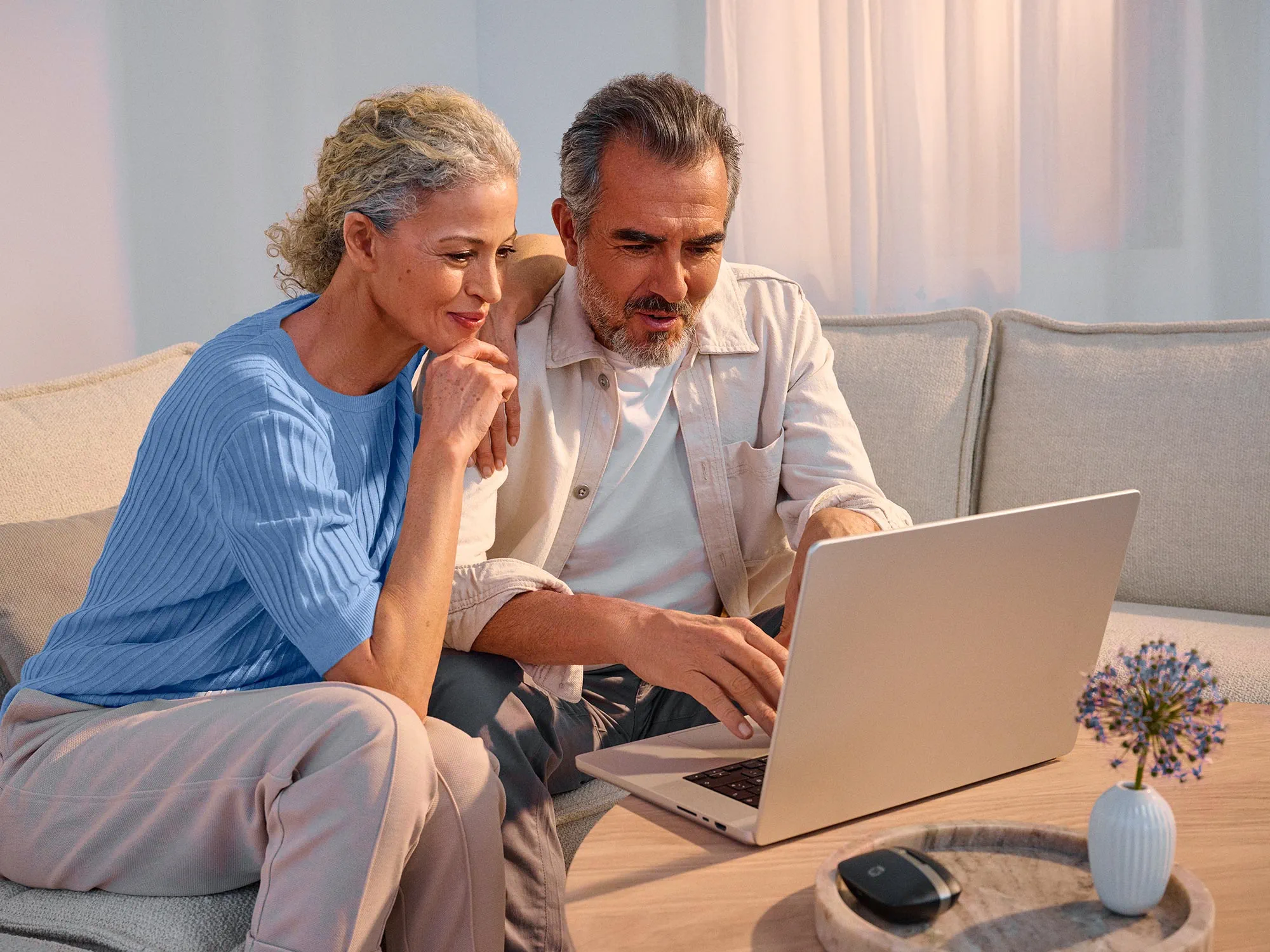 Couple researching on technology together, with their hearing aids on.