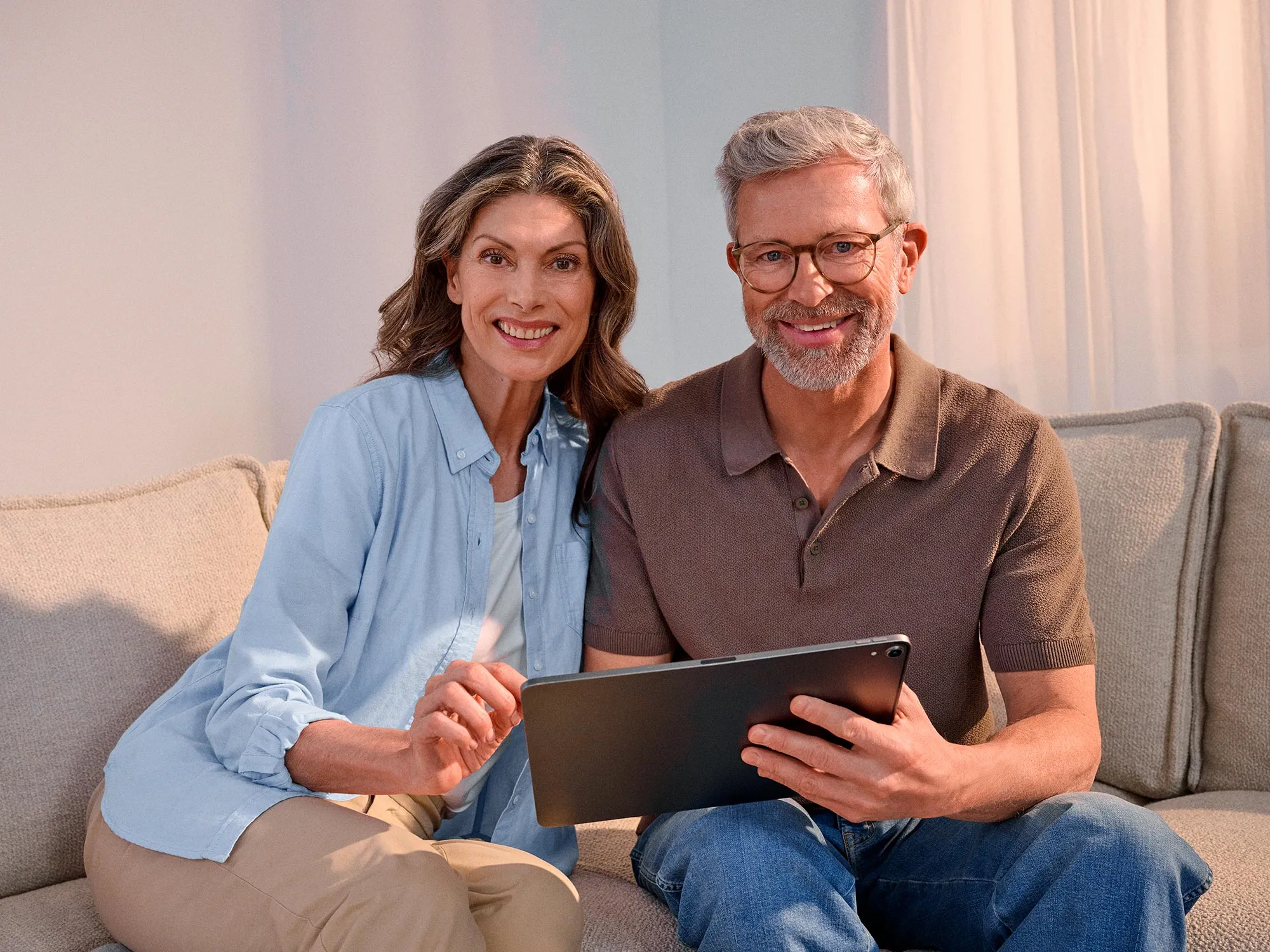 Confident couple using technology, highlighting hearing improvement.