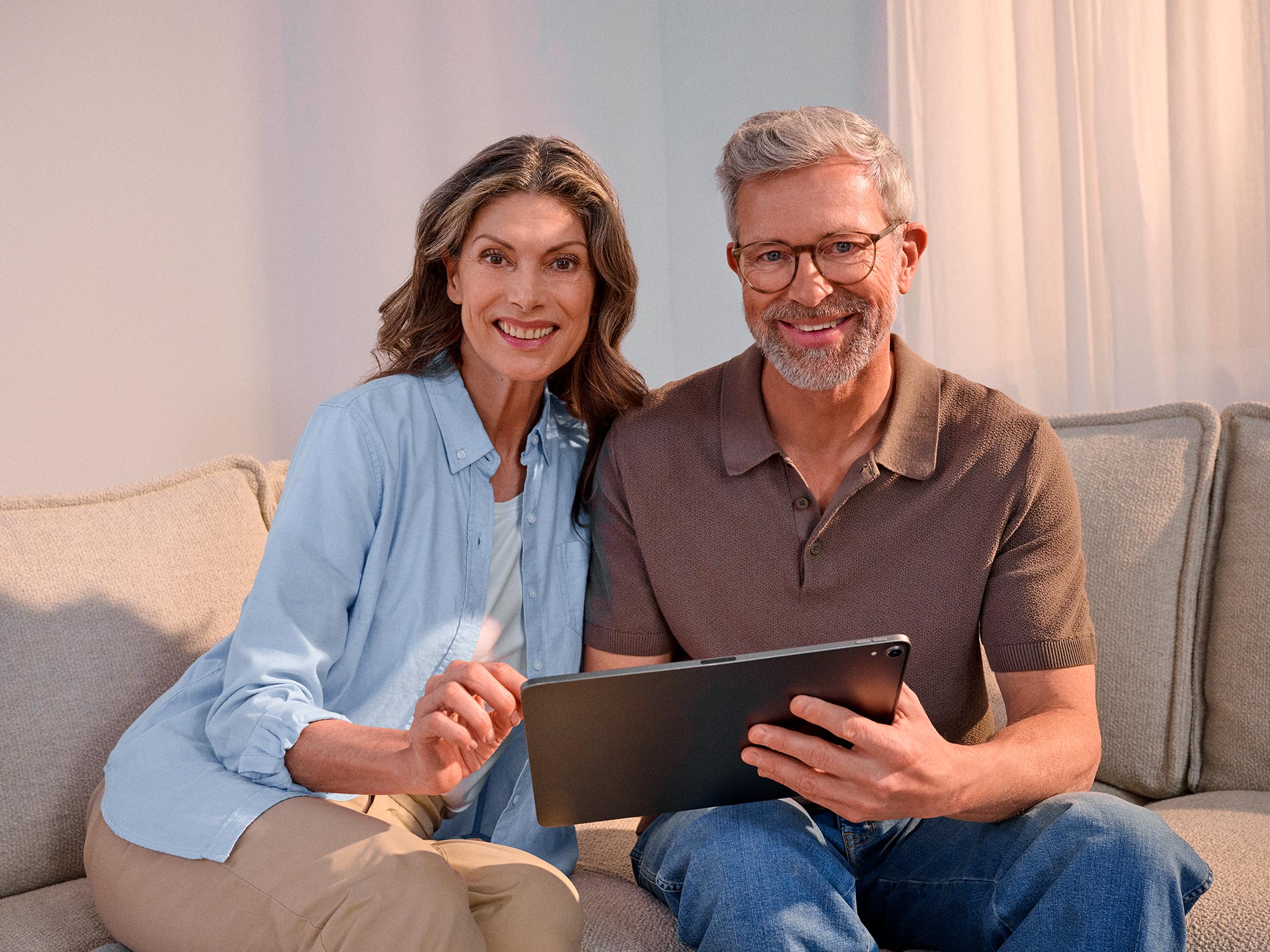 Confident couple using technology, highlighting hearing improvement.