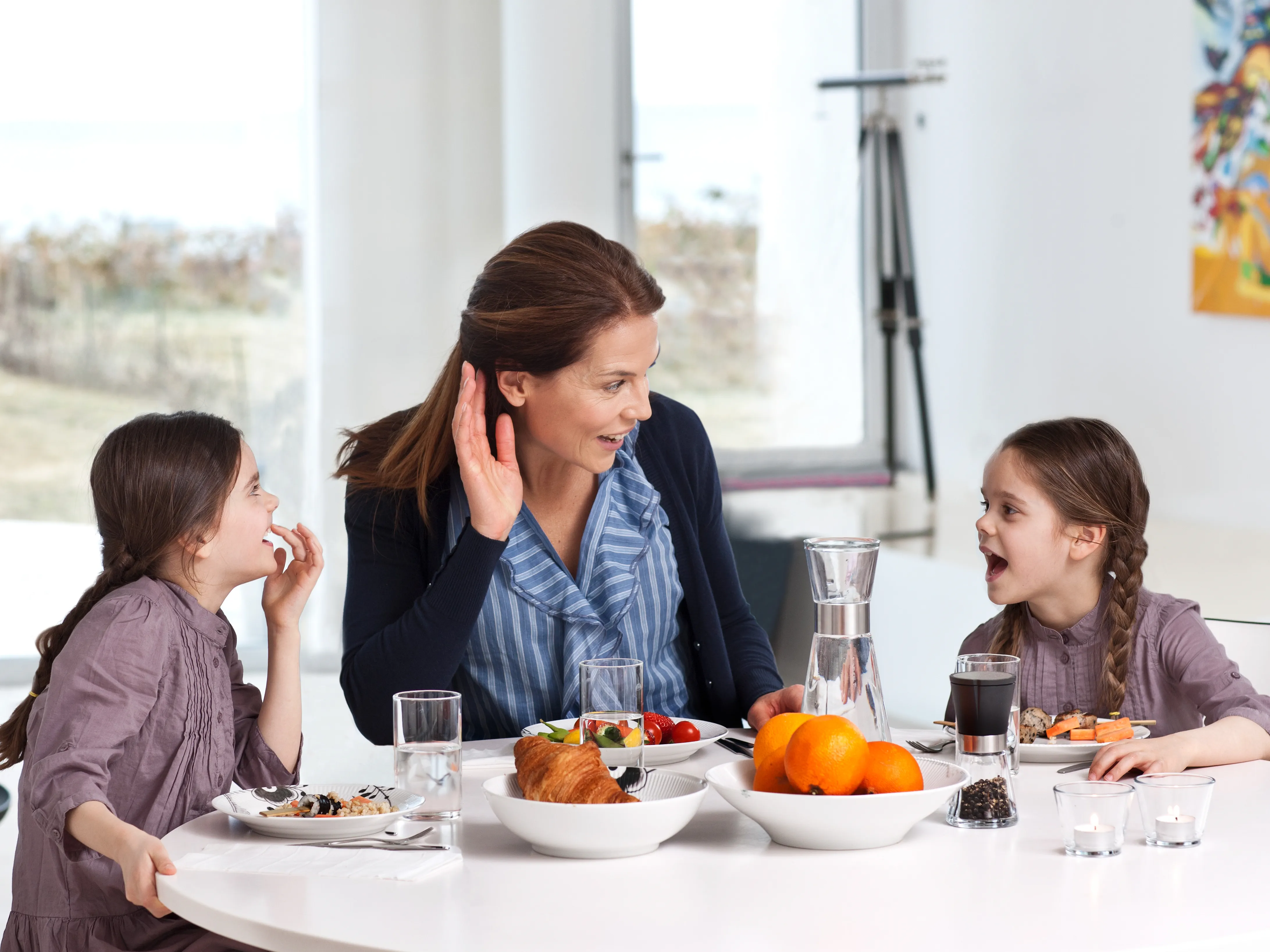 Mother spending time with her two daughters wearing hearing aids