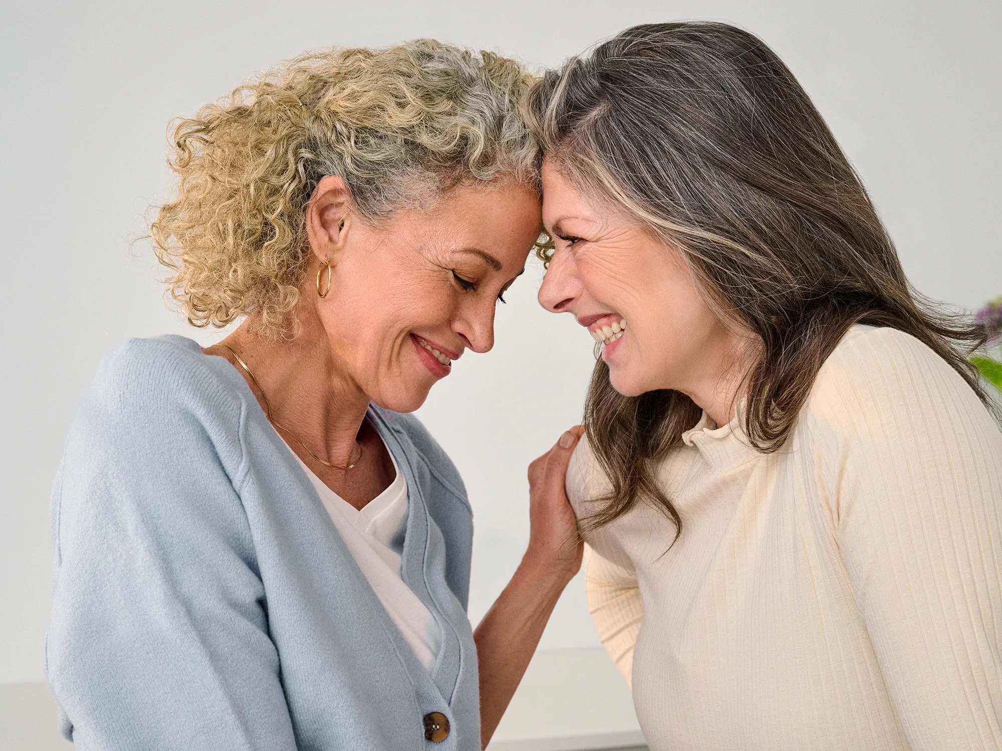 Close friends smiling and enjoying each other's company, celebrating hearing improvement.