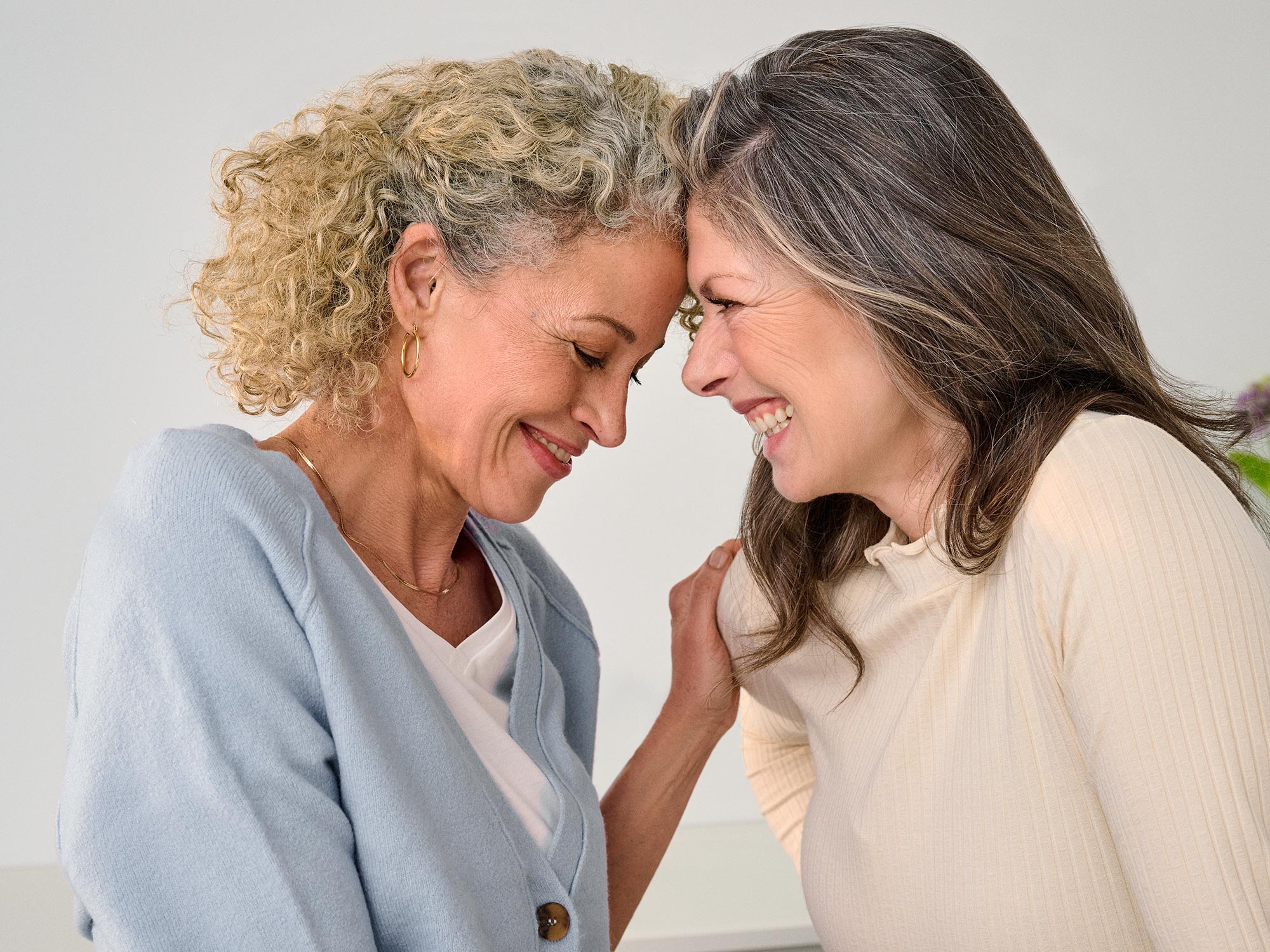 Close friends smiling and enjoying each other's company, celebrating hearing improvement.