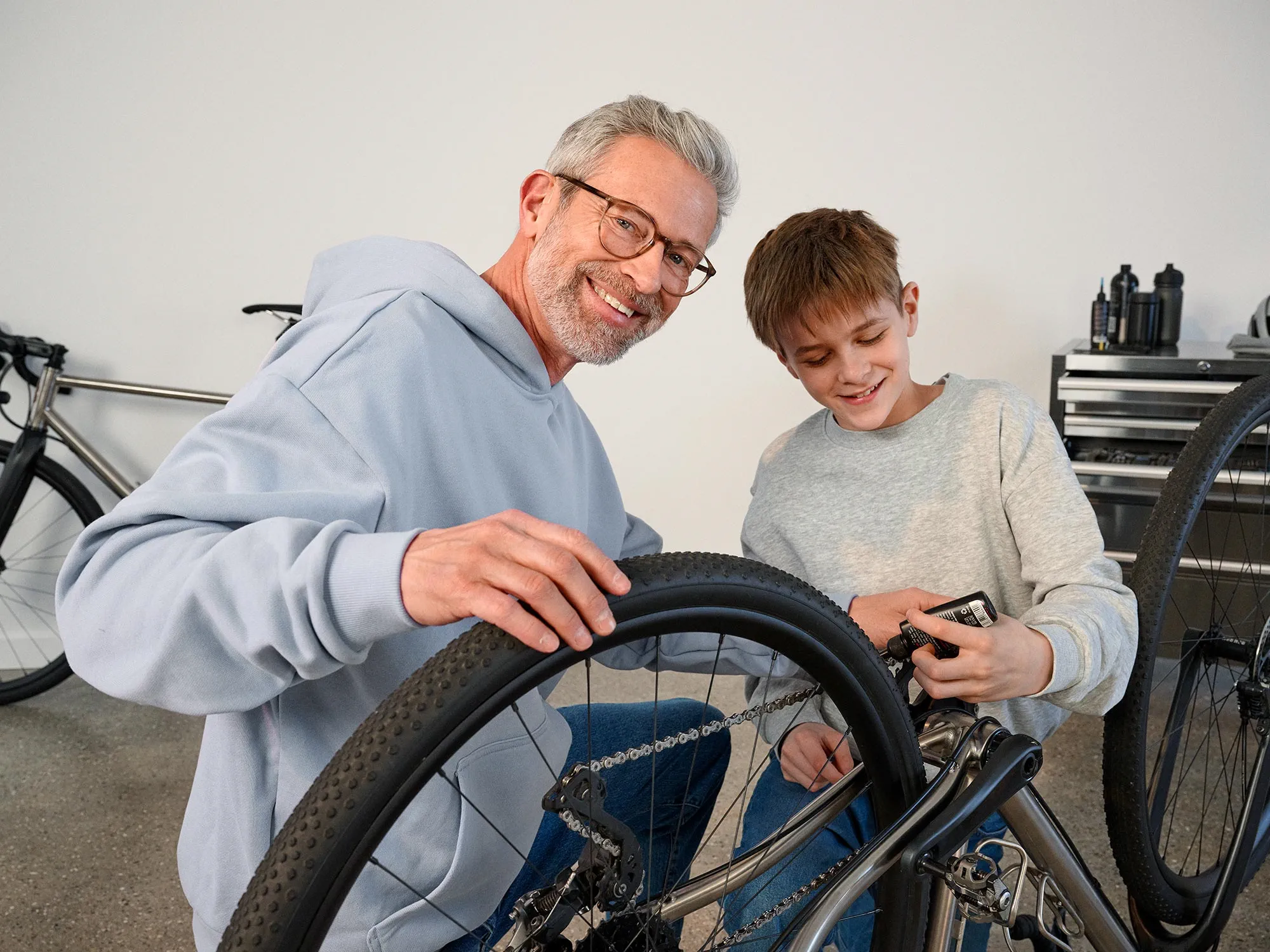 Grandparent and boy with a bike, both wearing hearing aids.