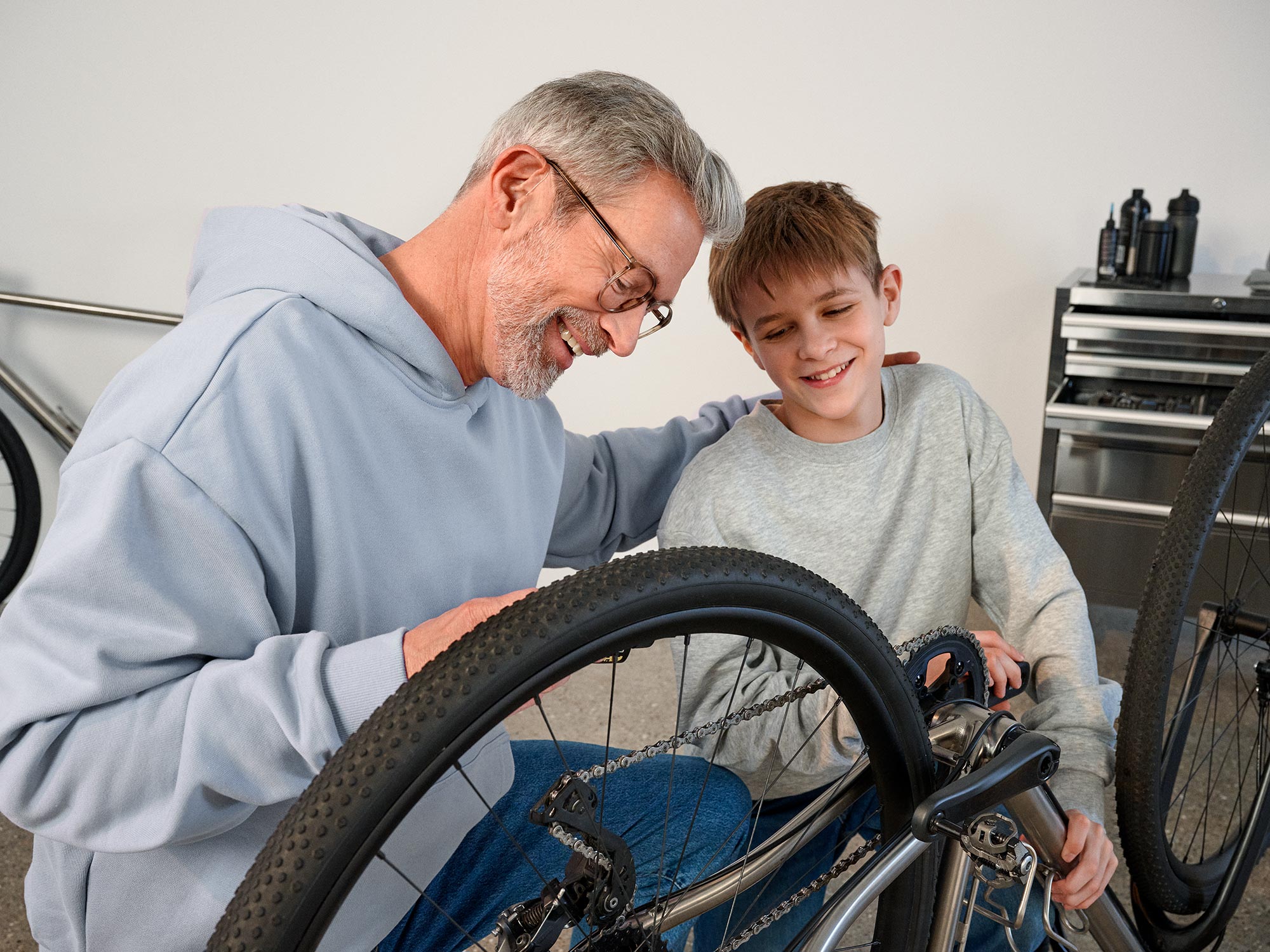 Grandparent repairing a bike while wearing hearing aids.