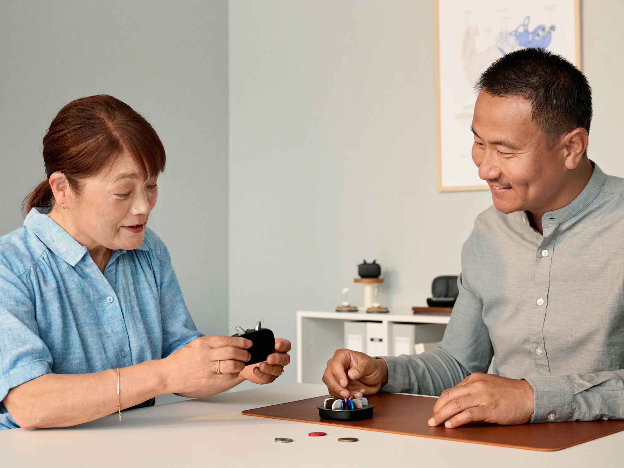 A customer selecting a hearing aid model while consulting with a hearing specialist.