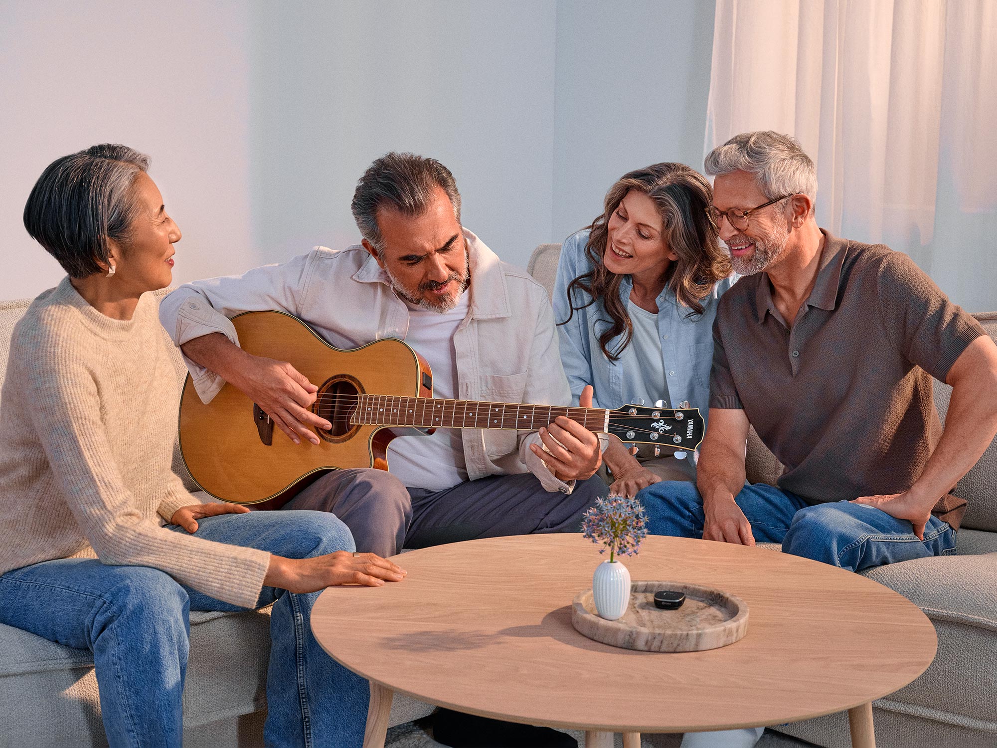 Friends enjoying a casual guitar session, appreciating their hearing improvement.