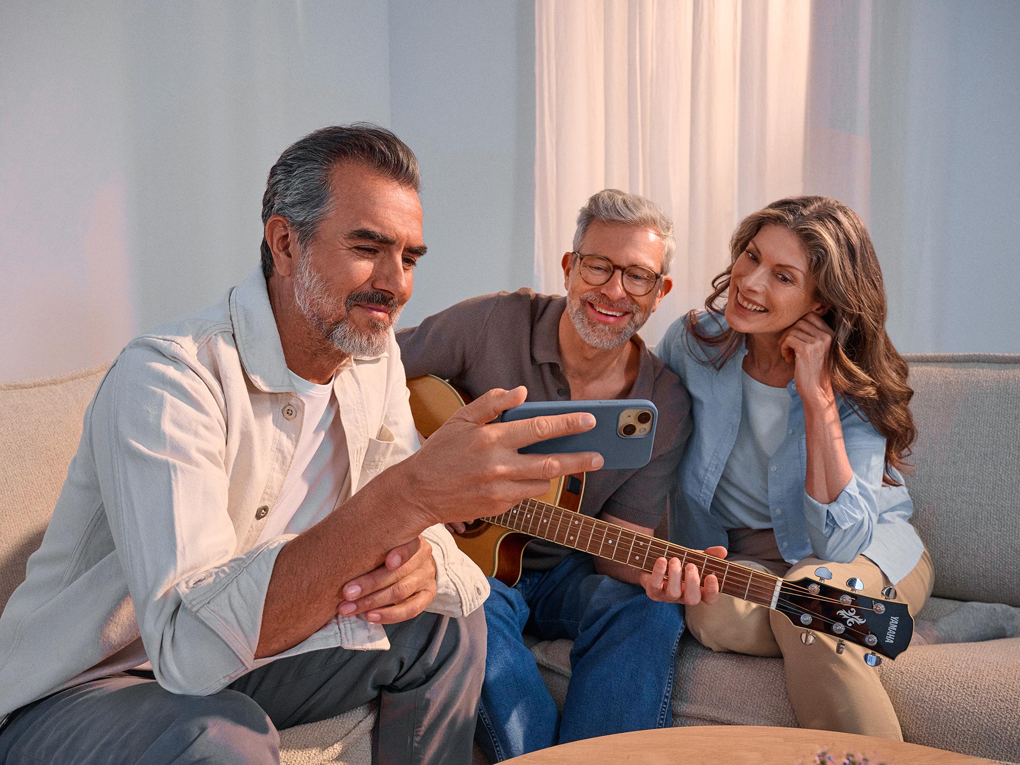 Friends watching something on a phone, celebrating their hearing improvement.