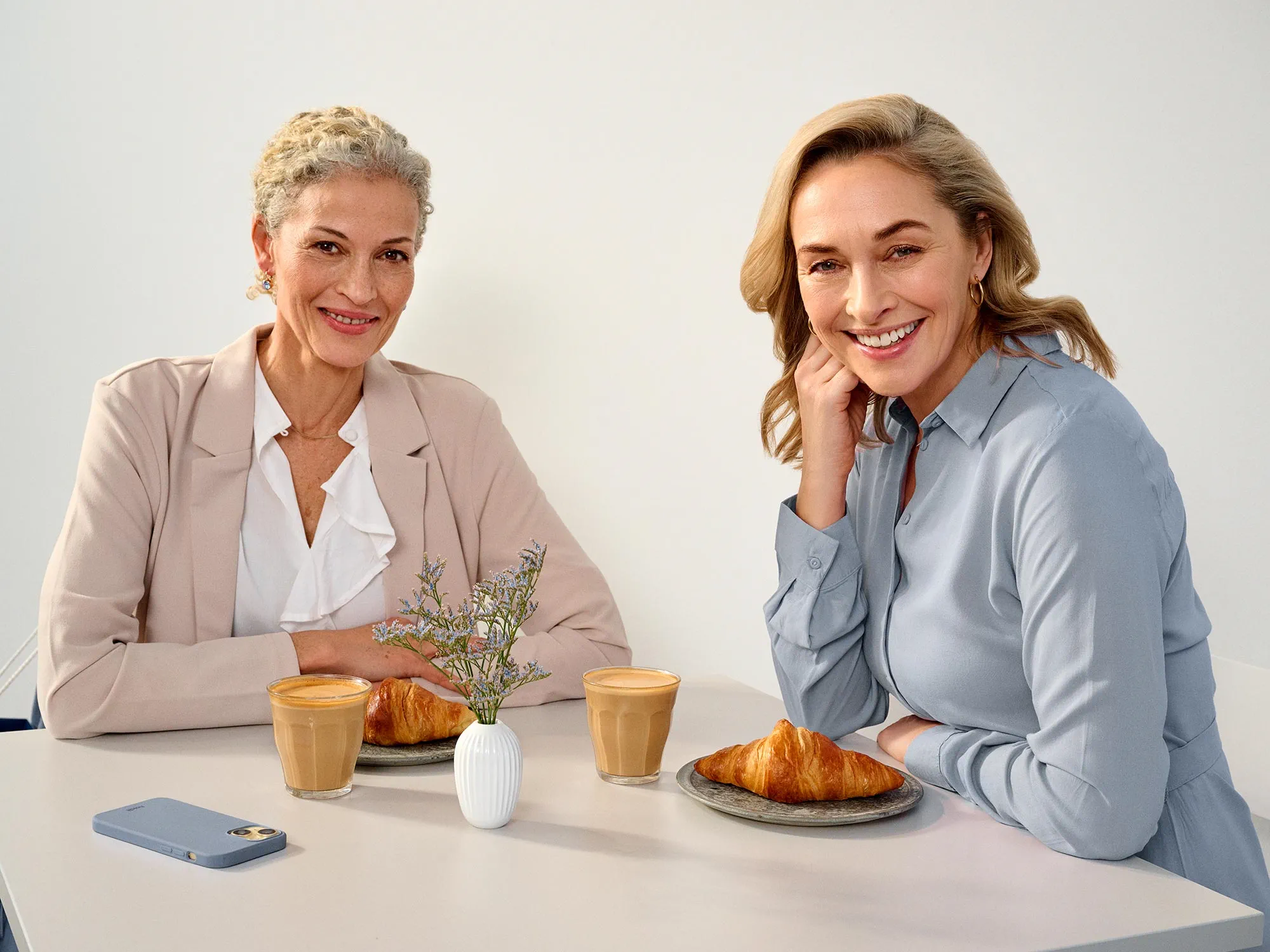 Friends enjoying time at a cafe, wearing hearing aids.