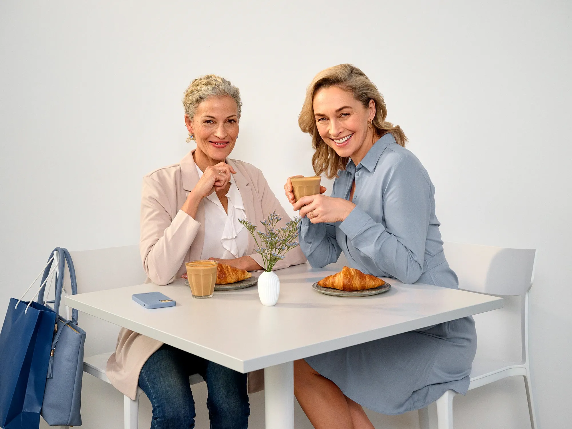 Friends sitting at a cafe, wearing hearing aids.