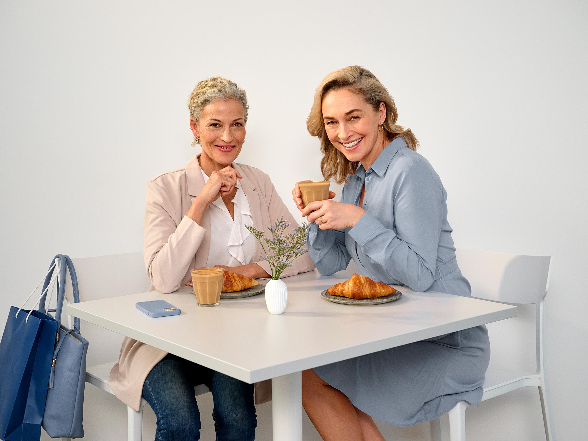 Freunde sitzen in einem Café und tragen Hörgeräte.
