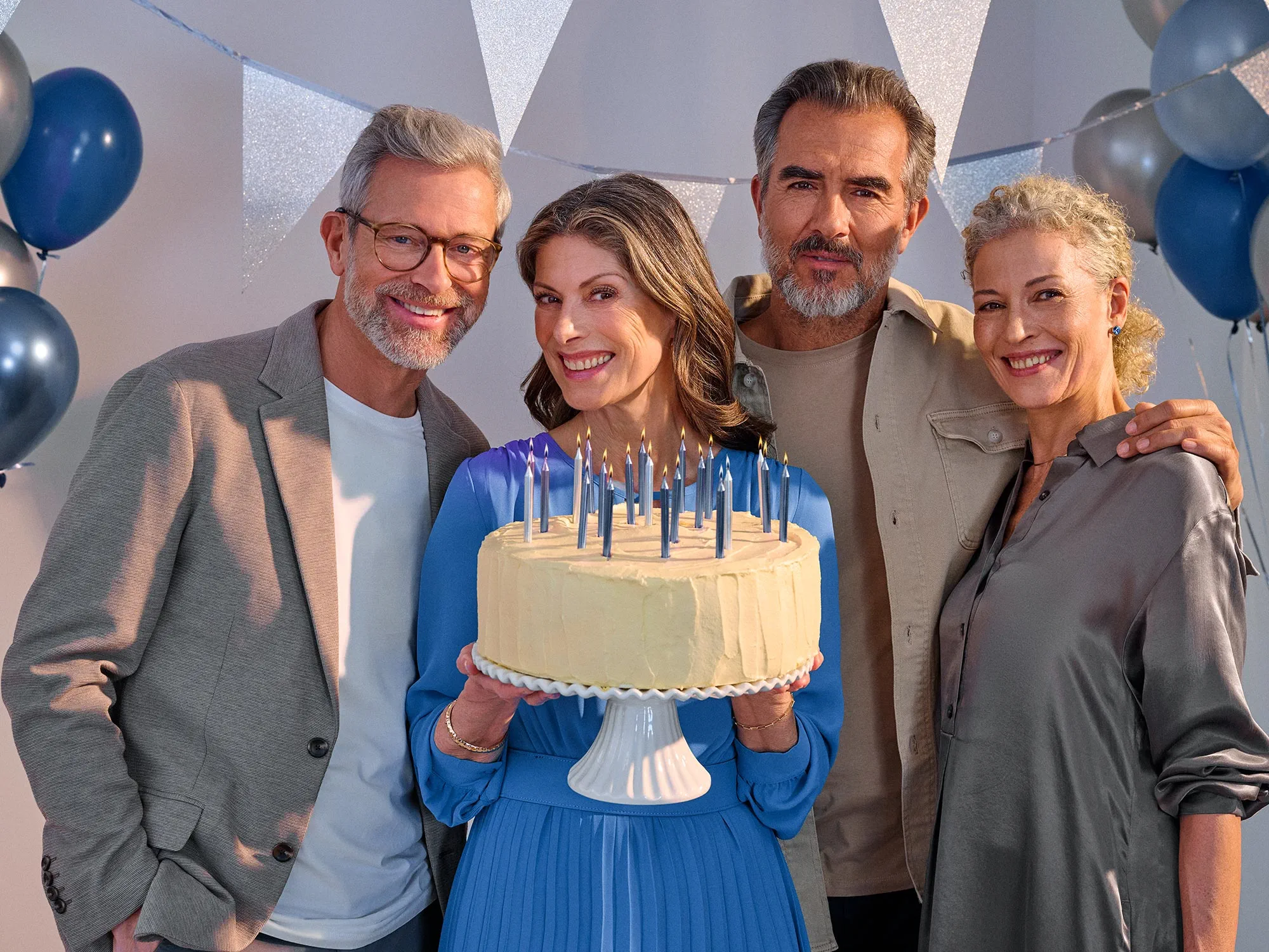 Happy friends celebrating a birthday, wearing hearing aids.