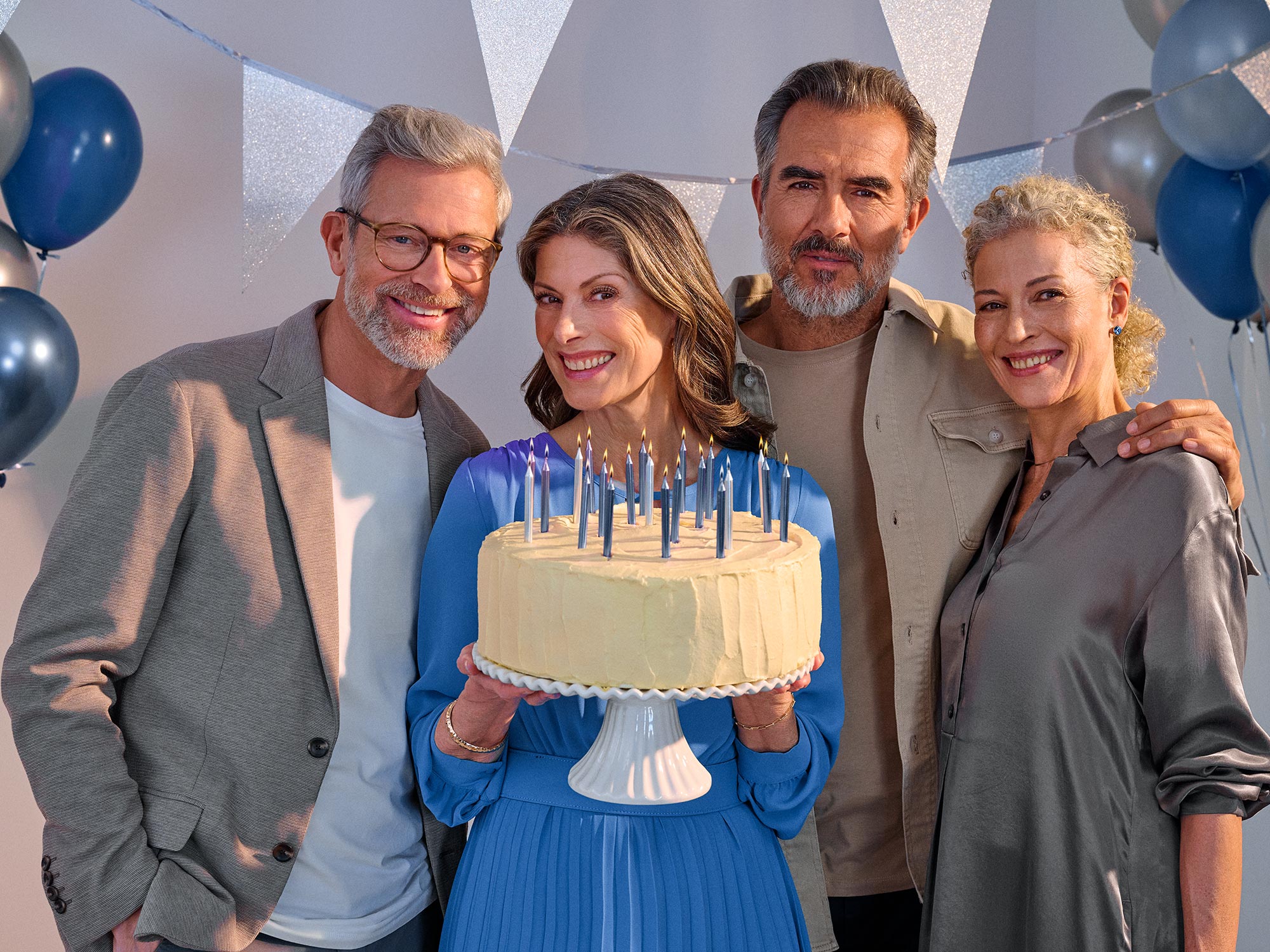 Happy friends celebrating a birthday, wearing hearing aids.