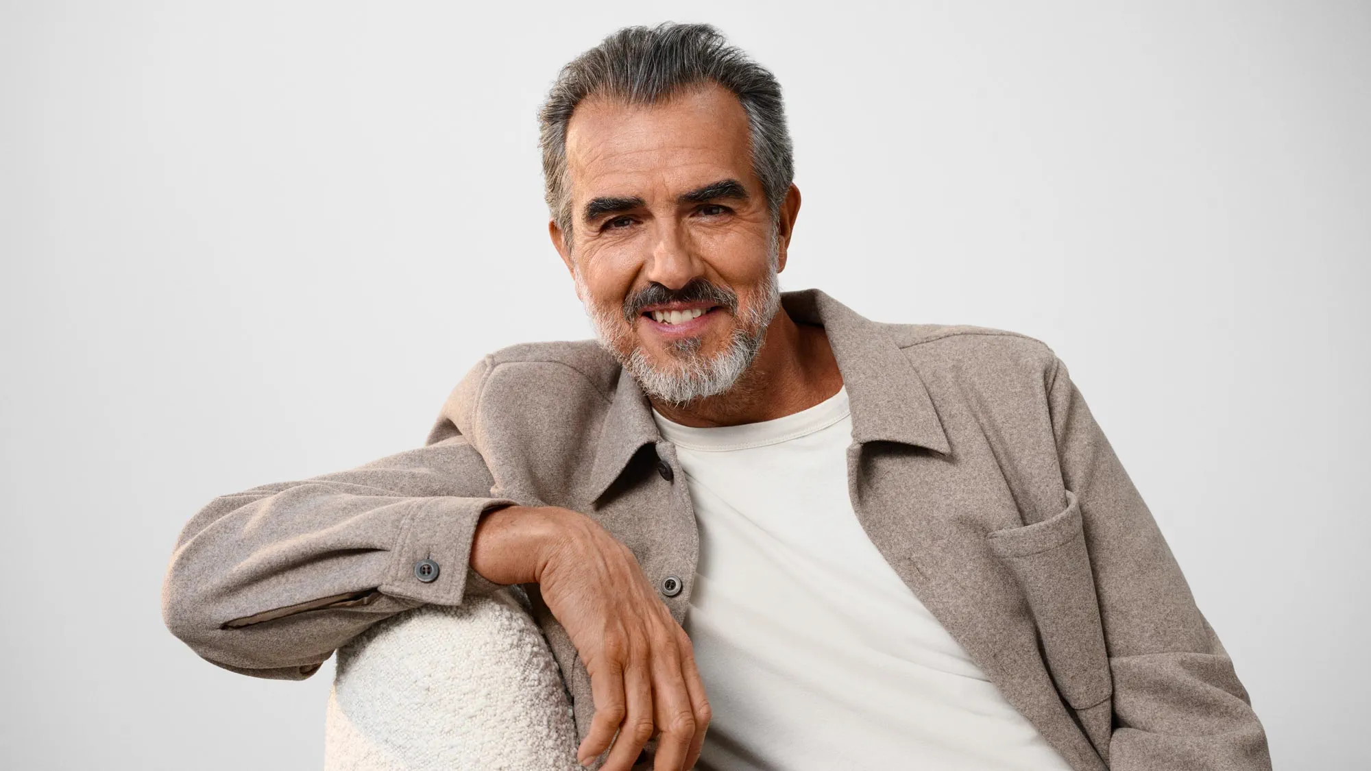 Comfortable man laughing, wearing hearing aids.